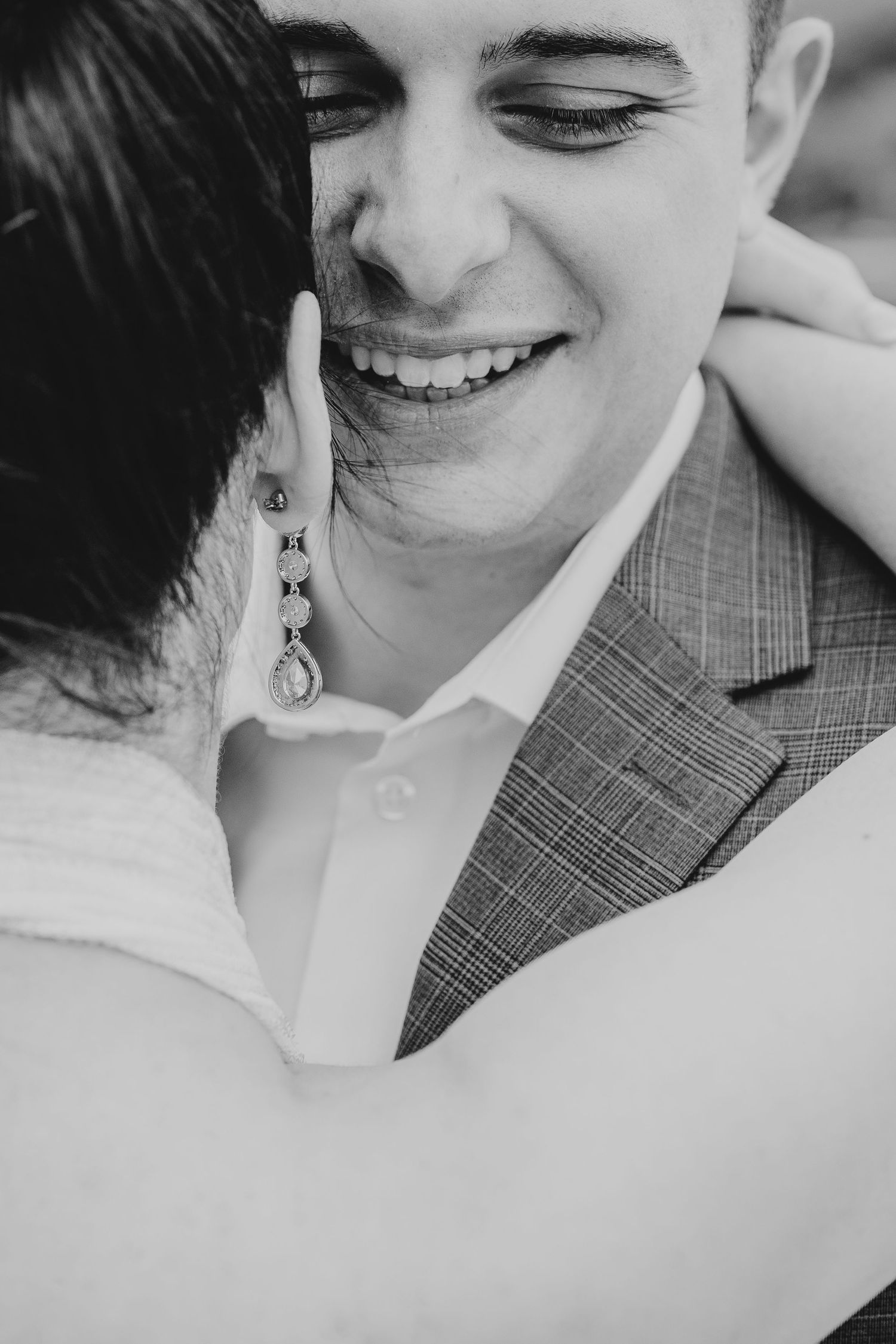 Black and white close-up shot of a couple sharing a joyful moment.