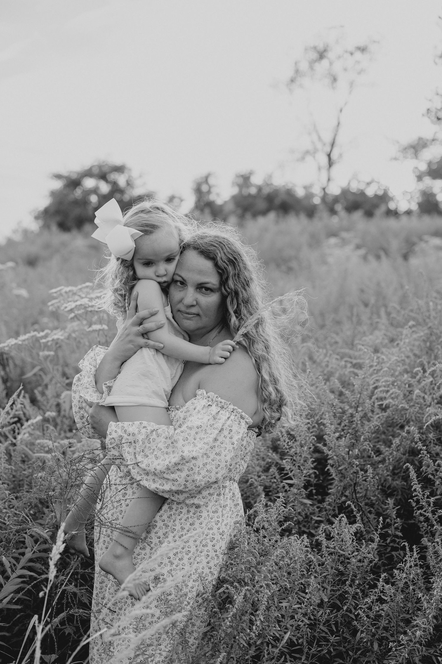 Black and white photo showing tender moments between two people in a flowering field.