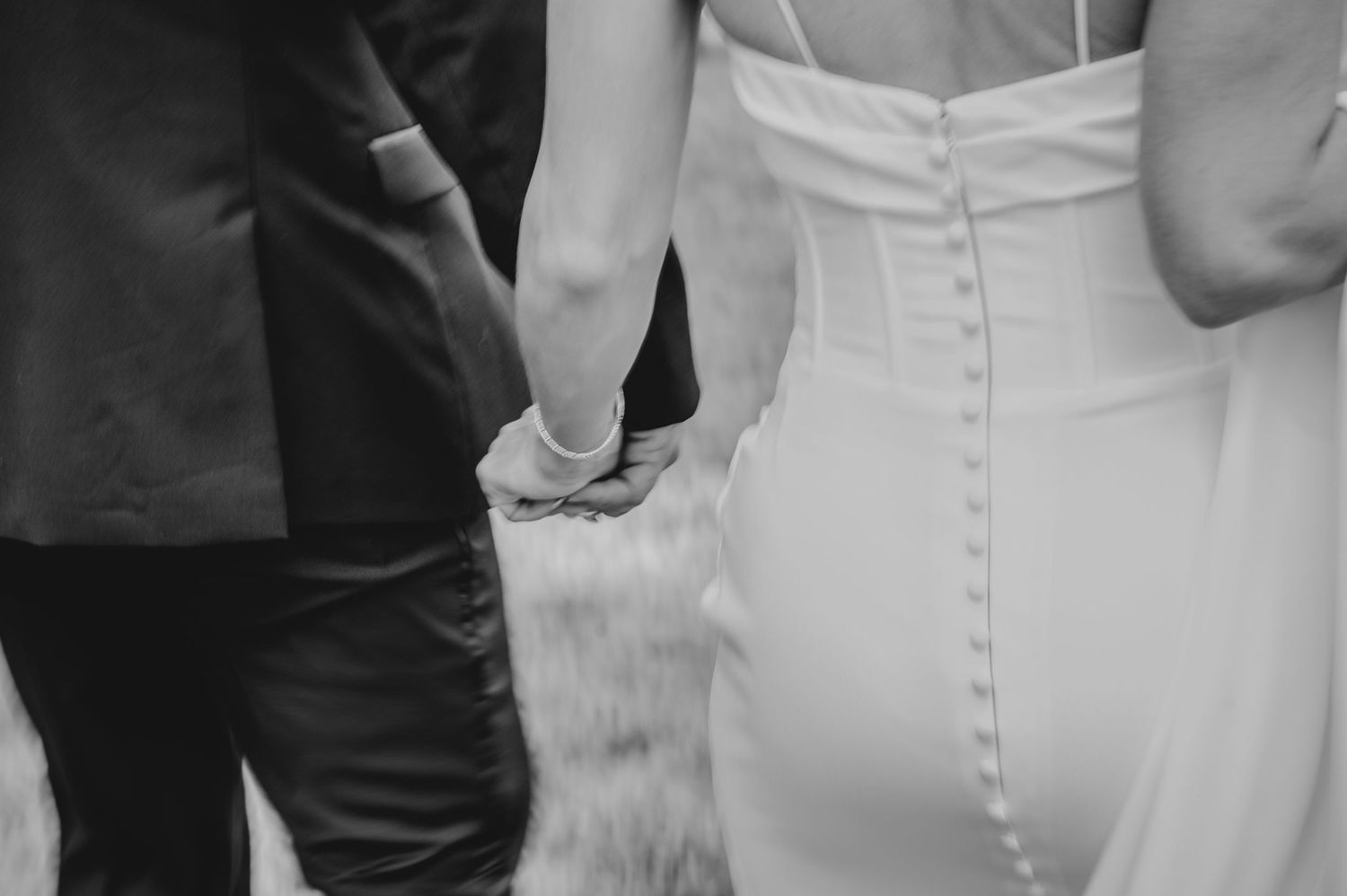 Close-up details of an elegant white wedding dress with button details.