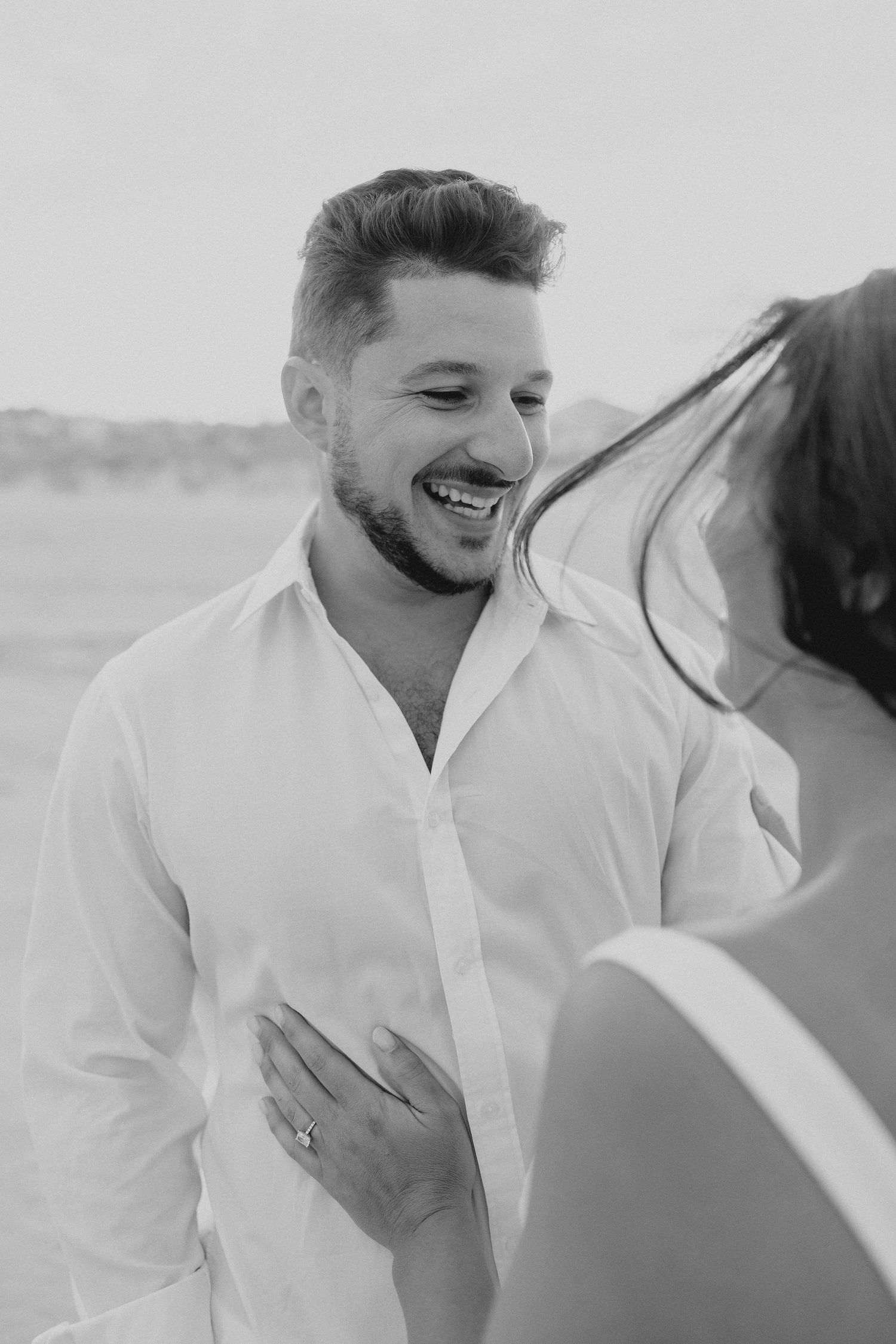 Black and white images of heartfelt reactions and emotions during a beach photo session.