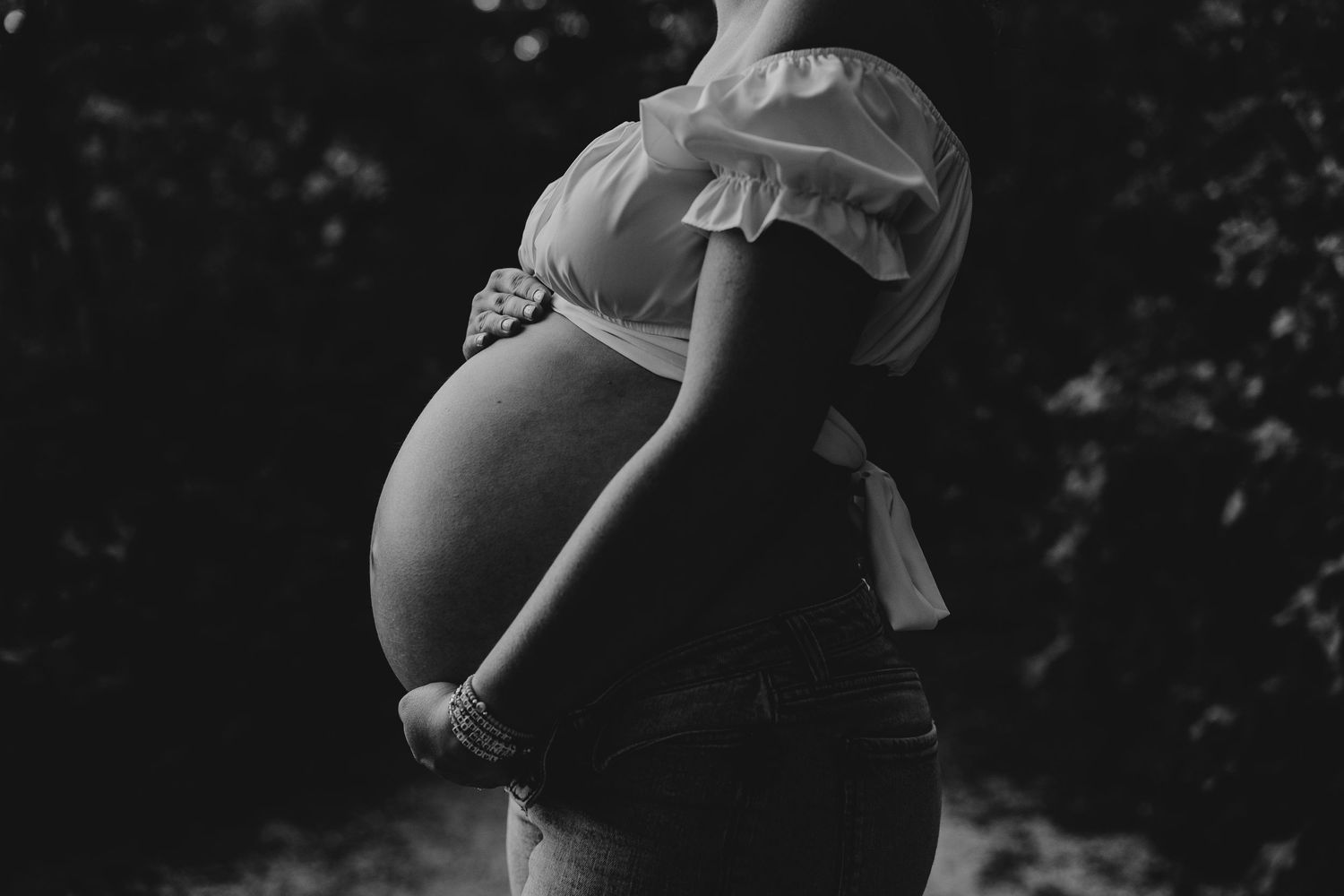 Dramatic black and white silhouette highlighting a pregnant belly.