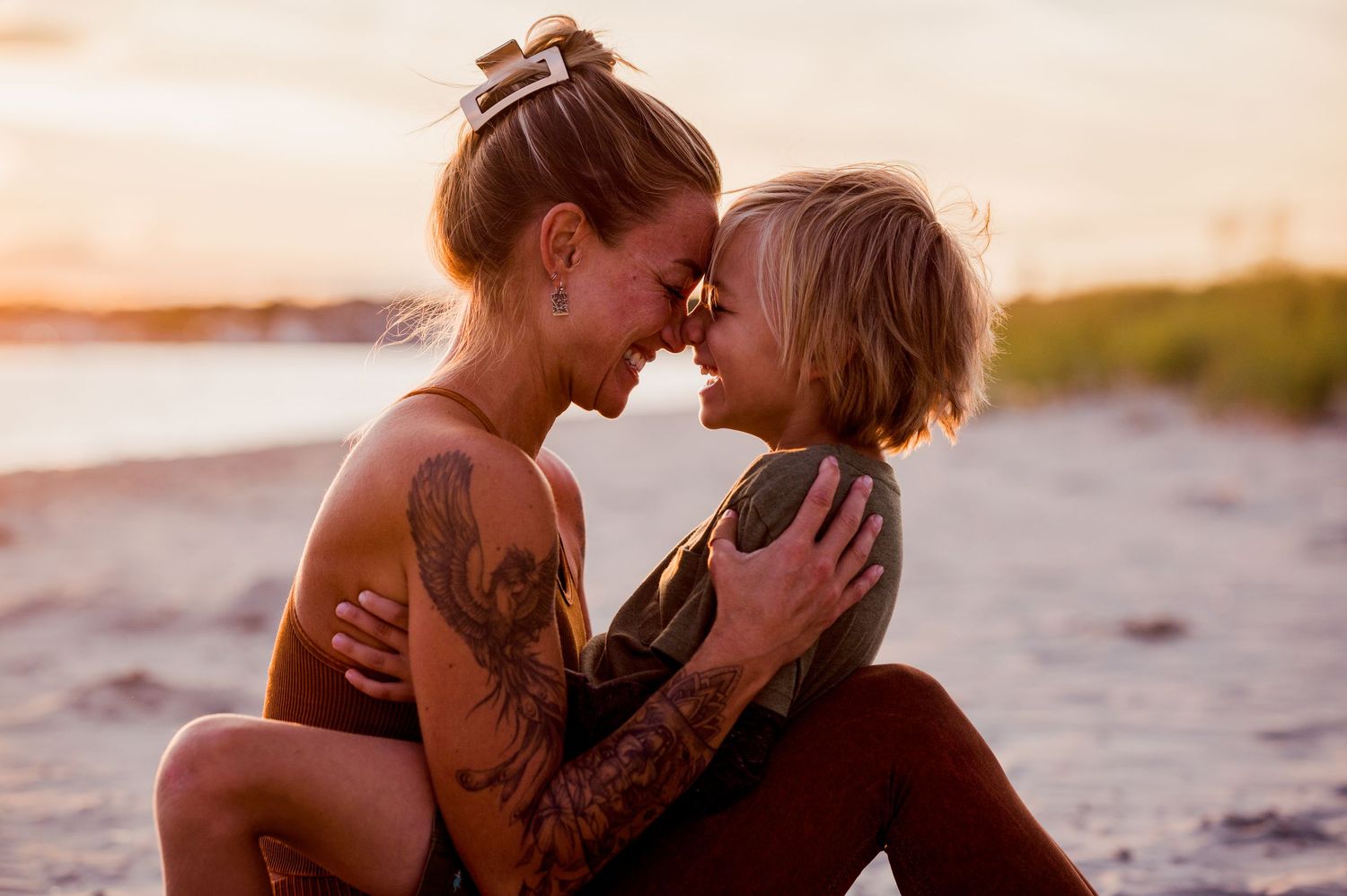 Romantic sunset beach photoshoot with couple in warm golden light.