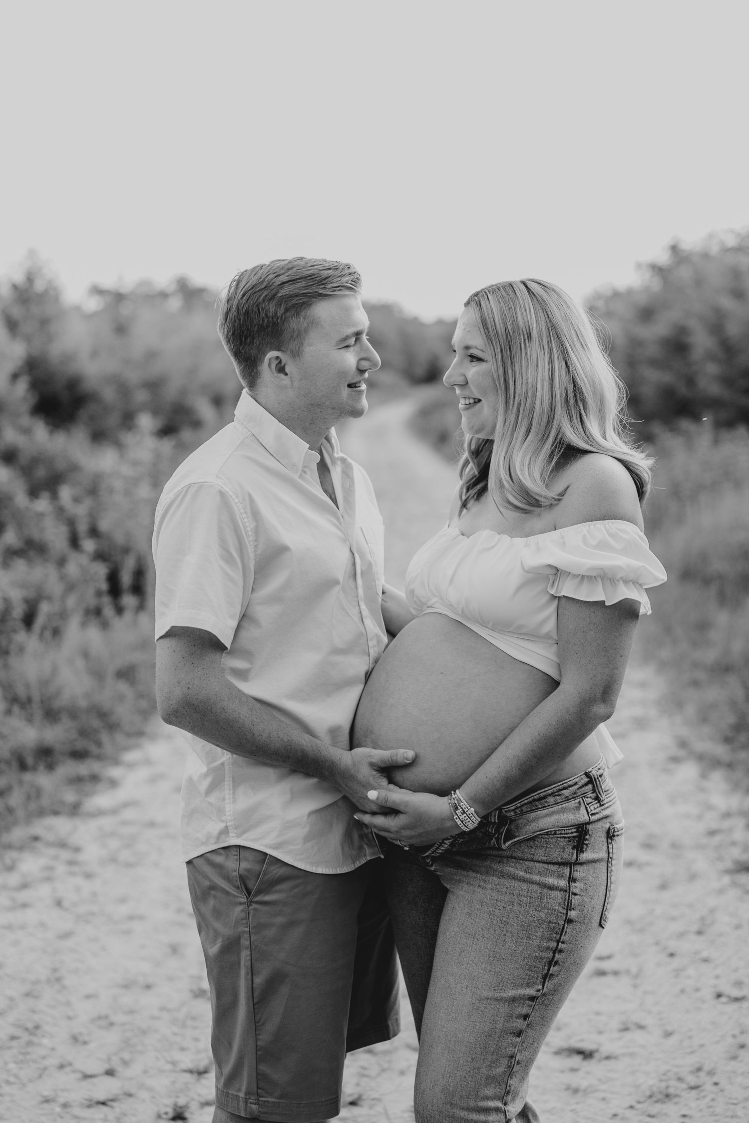 Black and white casual maternity photo on a nature path.