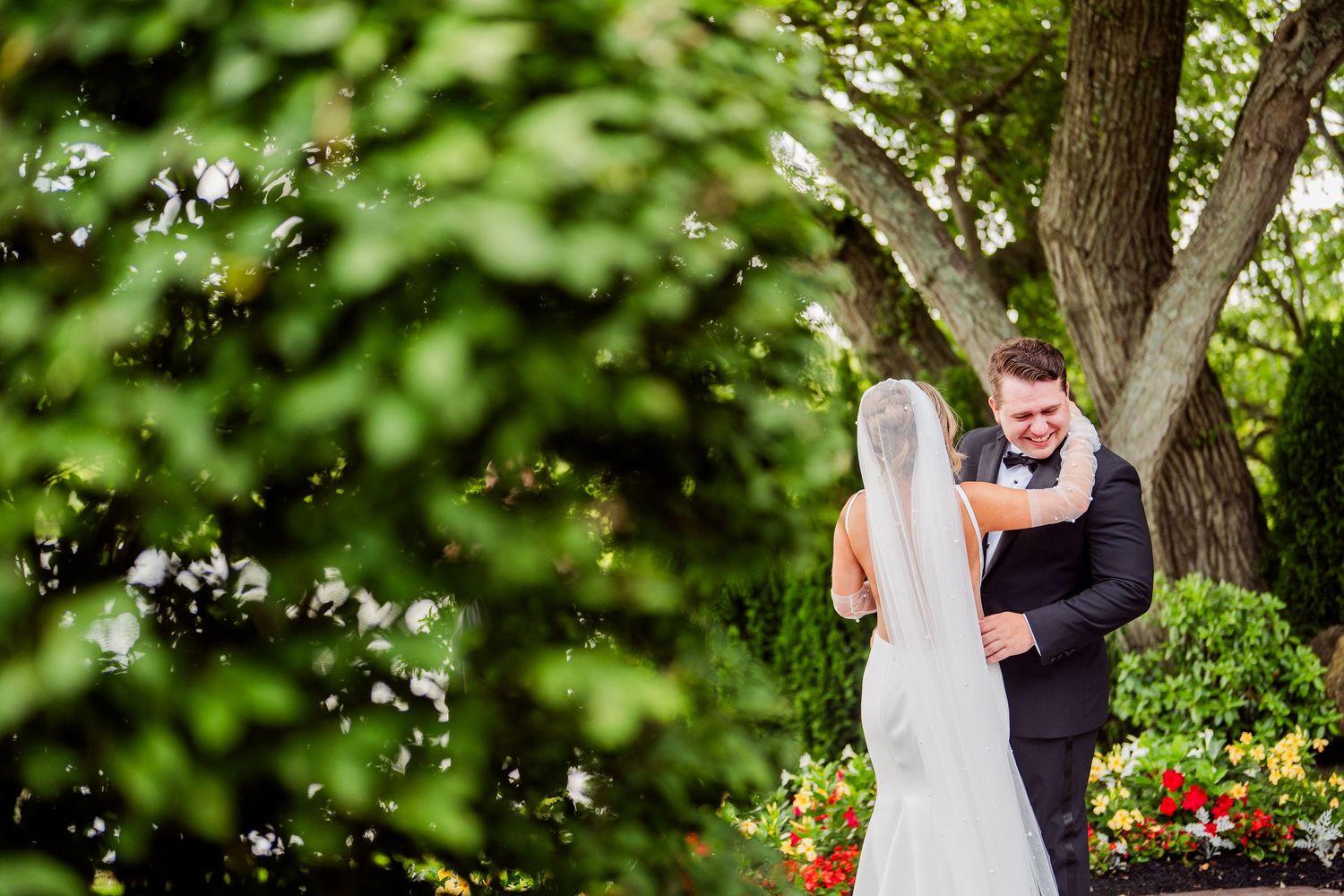 Intimate wedding moments photographed in a lush garden setting with flowering trees.
