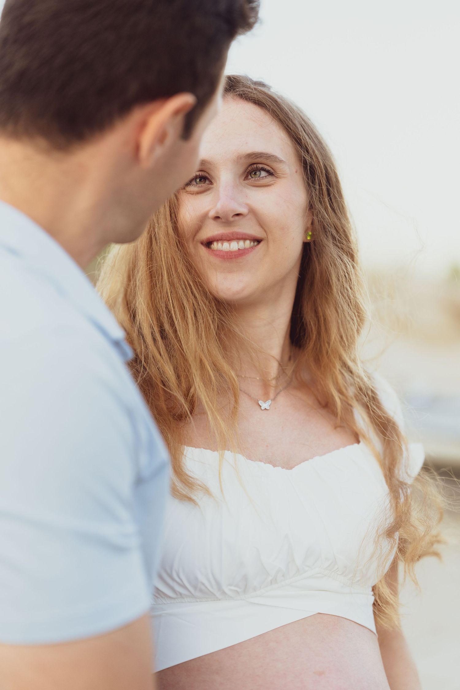 Romantic beach portrait session showing joyful expressions and natural light.