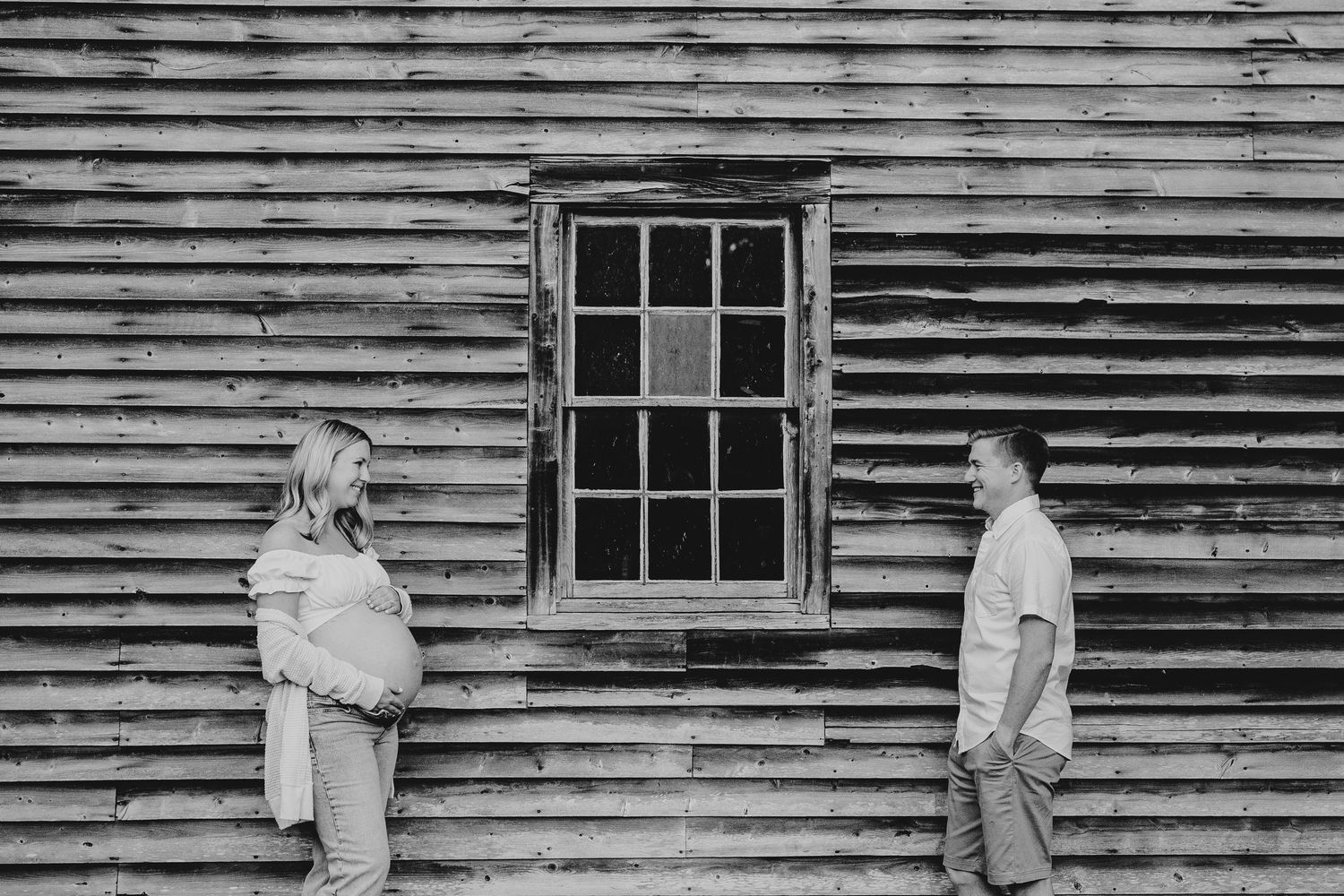 Rustic wooden barn wall with weathered siding and vintage windows.