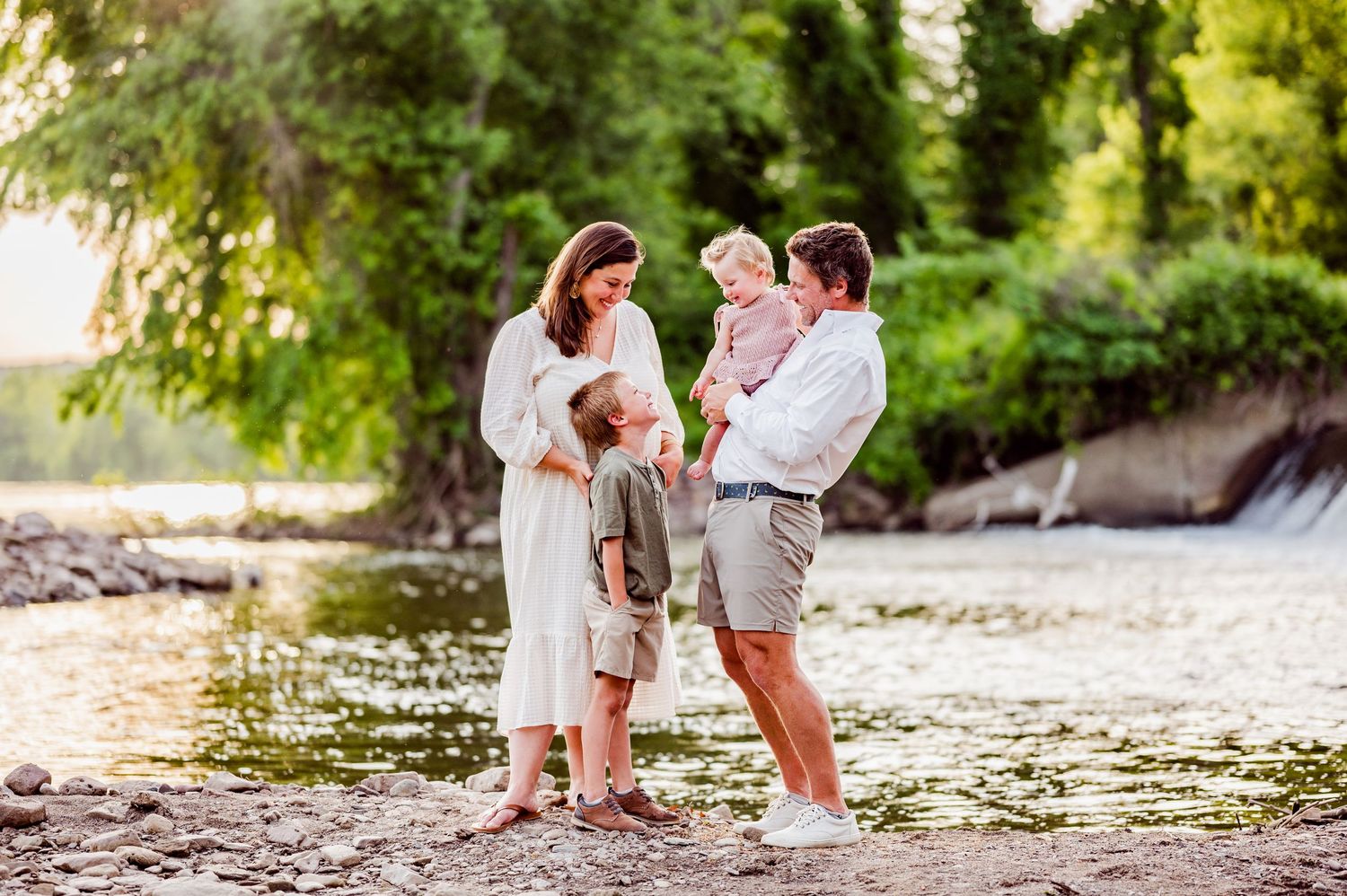 Family photoshoot by waterfront with white dresses and natural scenery.