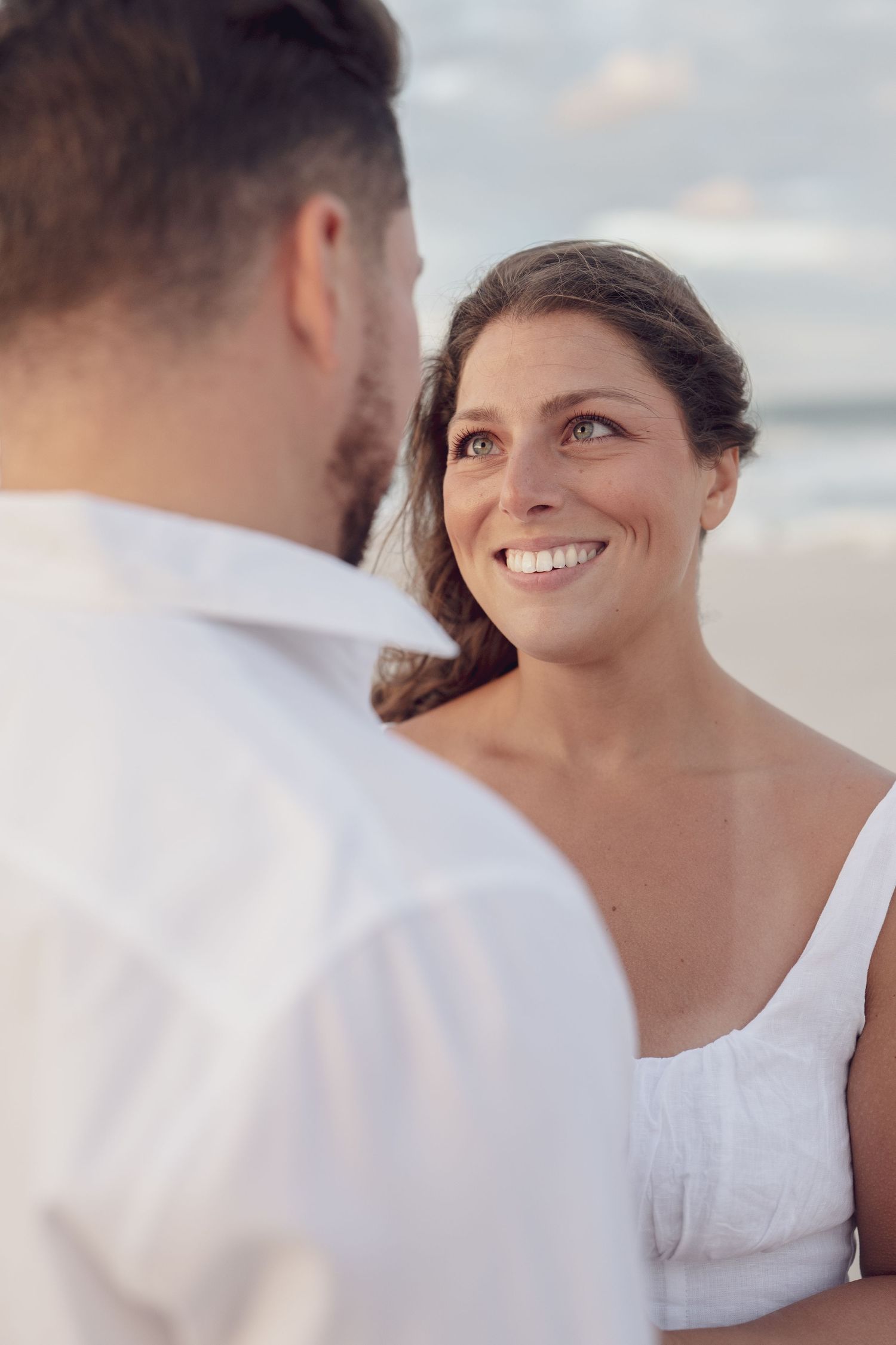 A series of candid beach photos showing a couple's genuine laughter and connection.