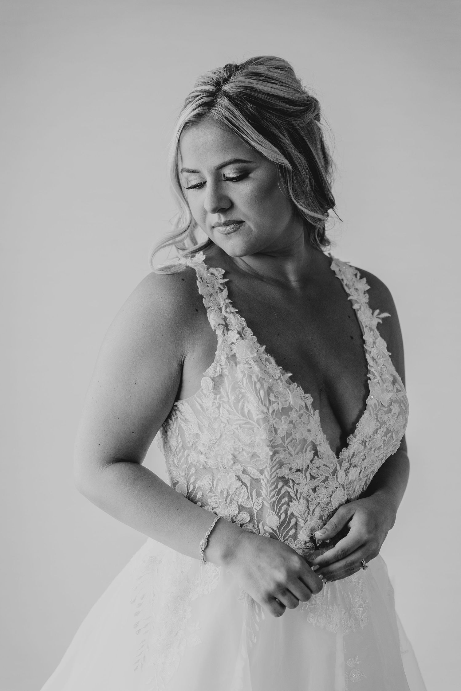 Black and white portrait highlighting delicate lace details of a wedding dress.