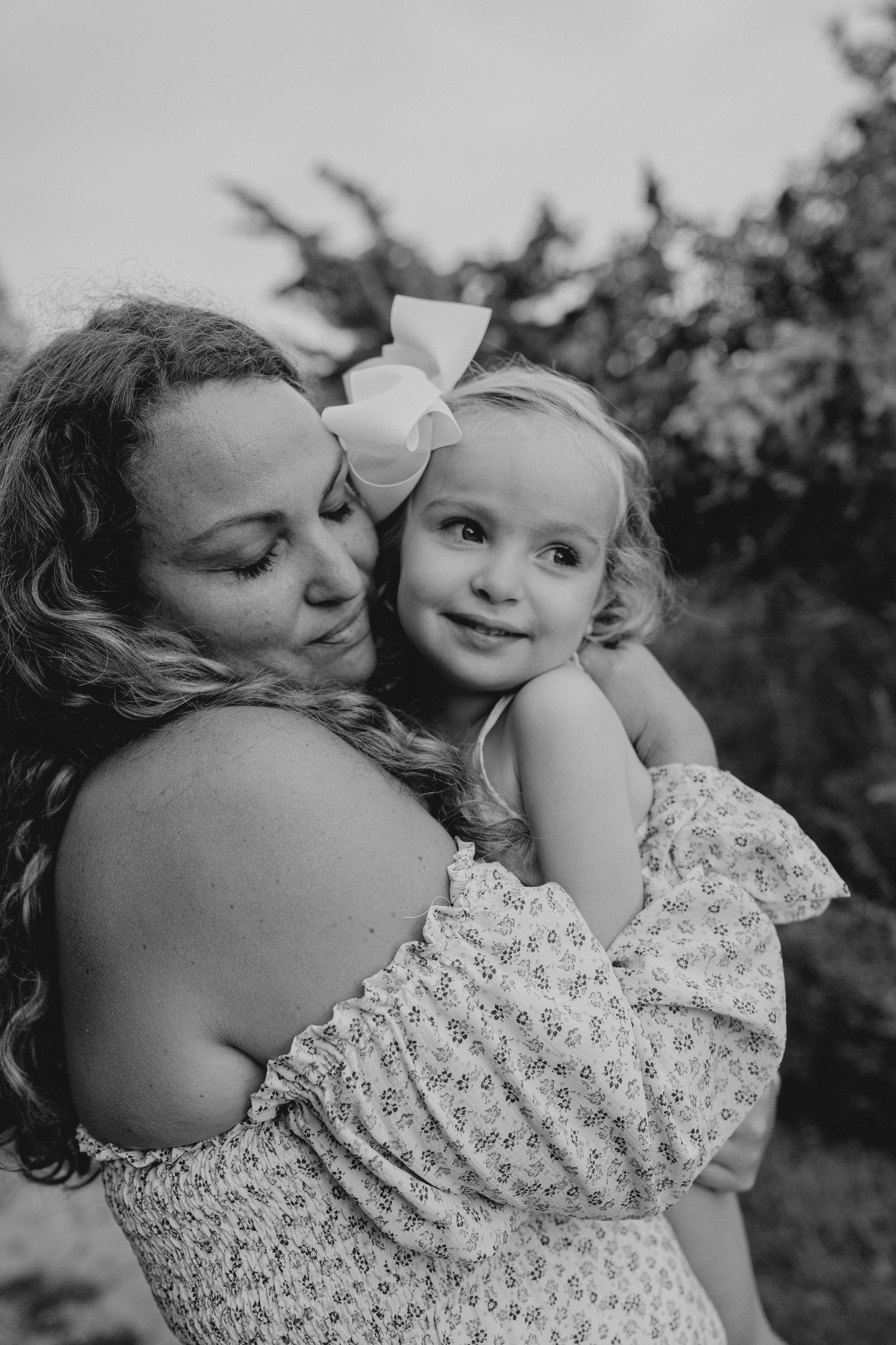 Black and white intimate portrait showing gentle embrace and connection outdoors.