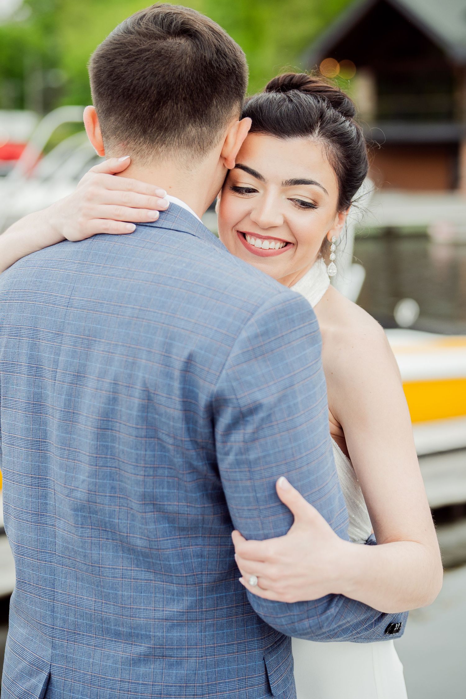 A couple embraces during their lakeside wedding photoshoot.