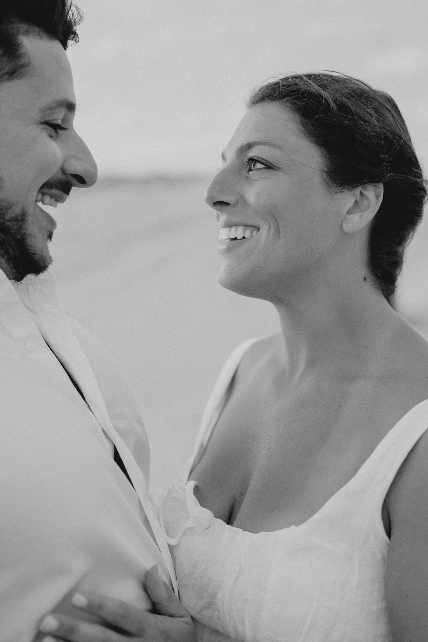 Black and white close-up shots of a couple laughing and sharing joyful moments together.