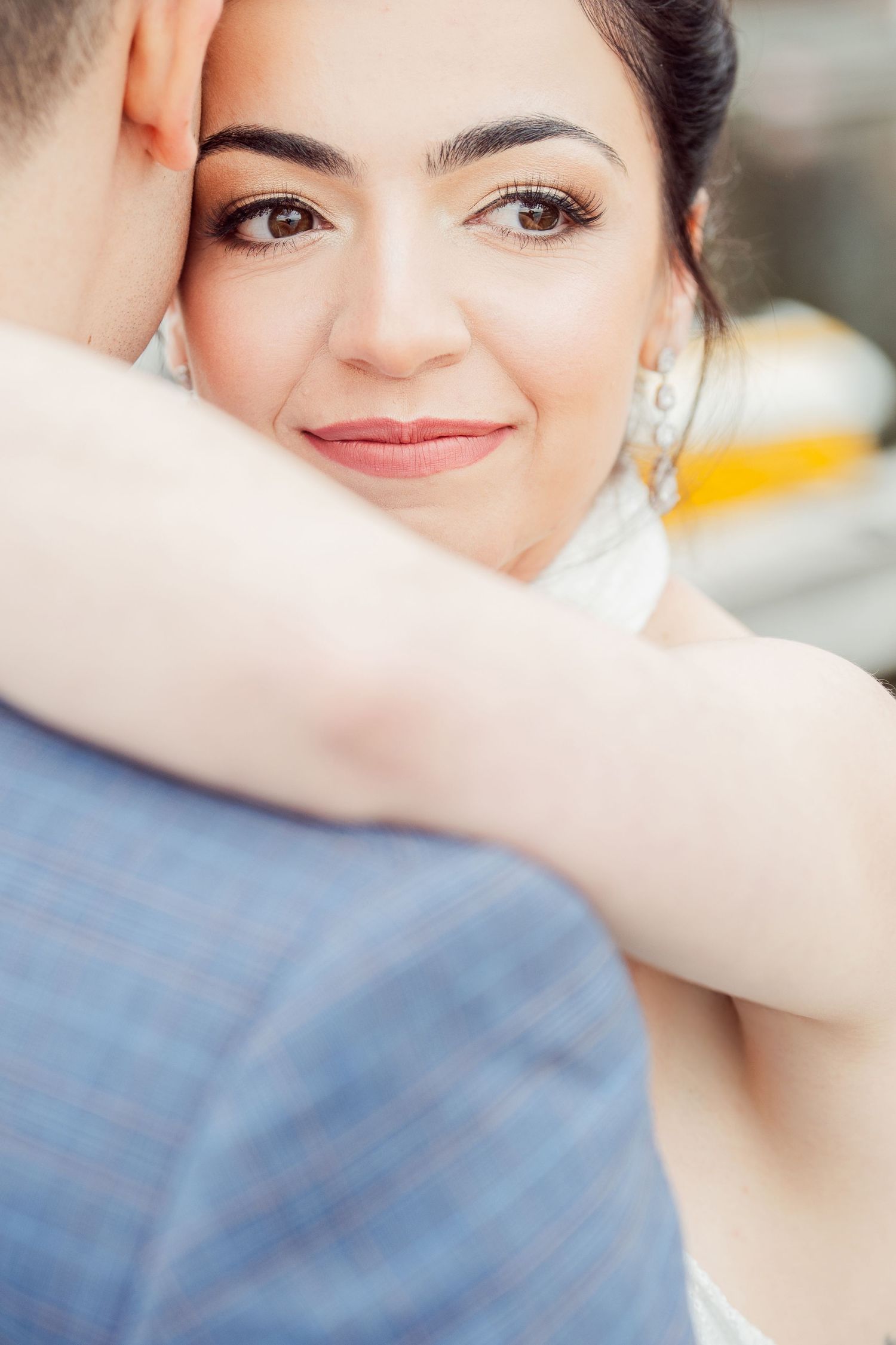 Intimate wedding portrait showing a bride's joyful expression during a close embrace.