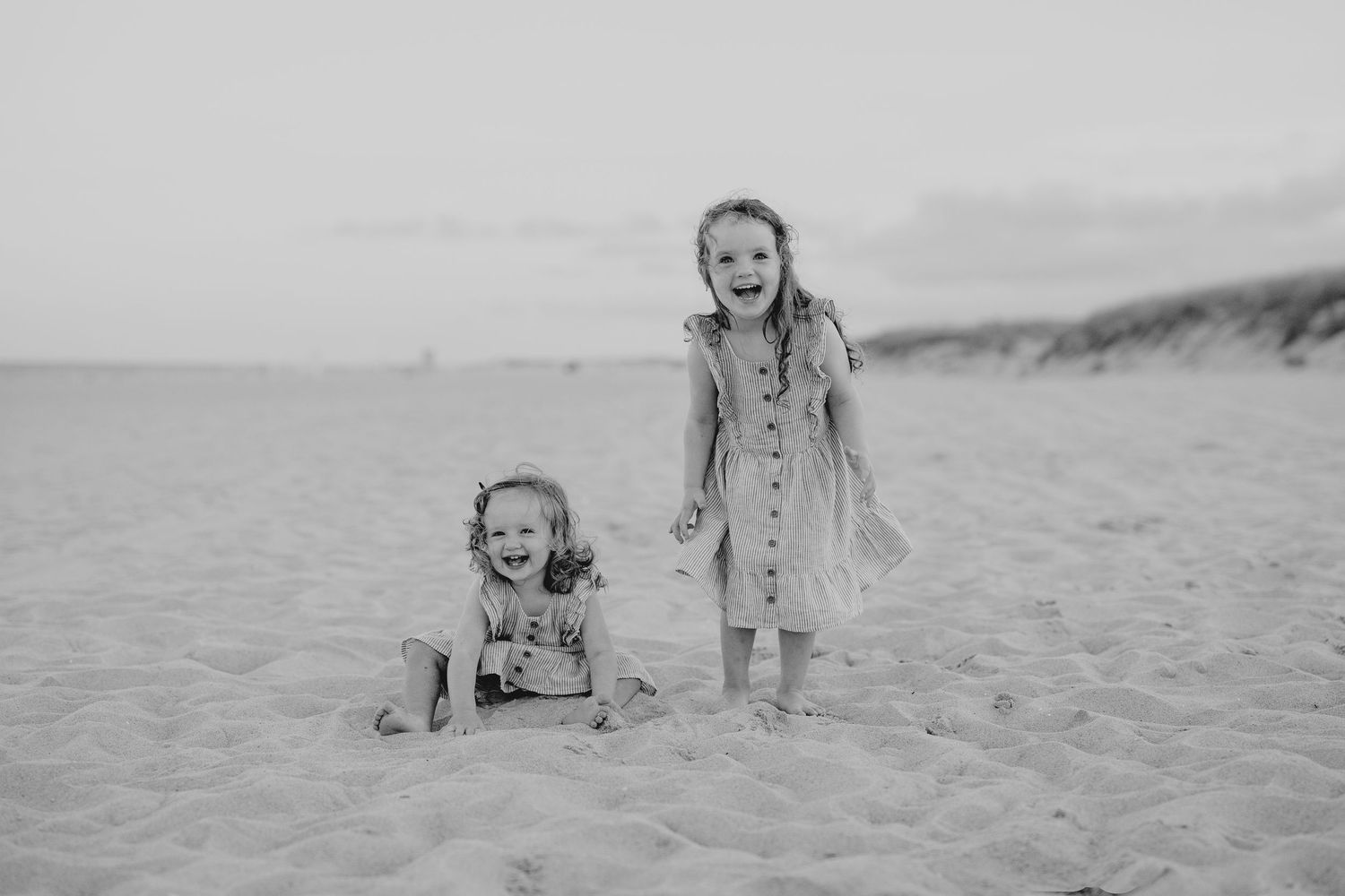 Black and white photo series of children playing and running on a sandy beach during summer.