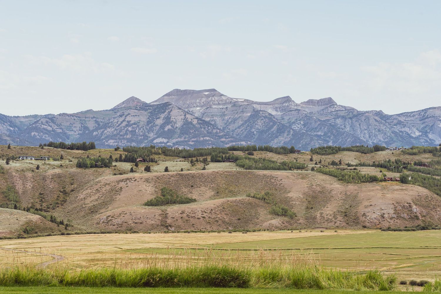 Panoramic view of rugged mountain ranges with rolling foothills stretching across a vast natural landscape.