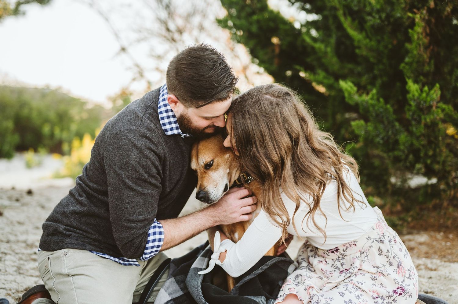 Intimate engagement session photos of couple cuddling on rocky beach.
