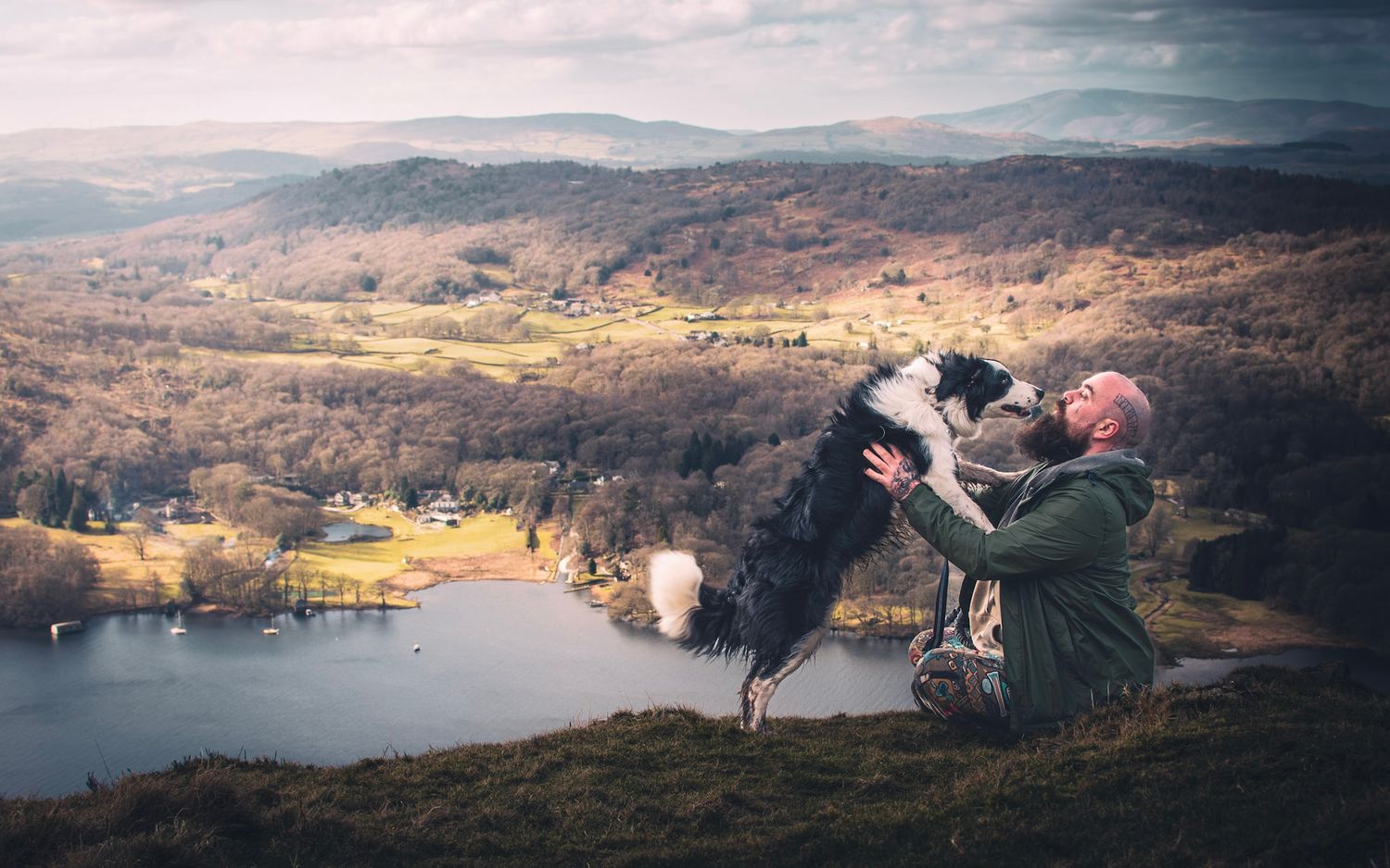 Border Collie and owner pictured on a mountain side in the Lake District