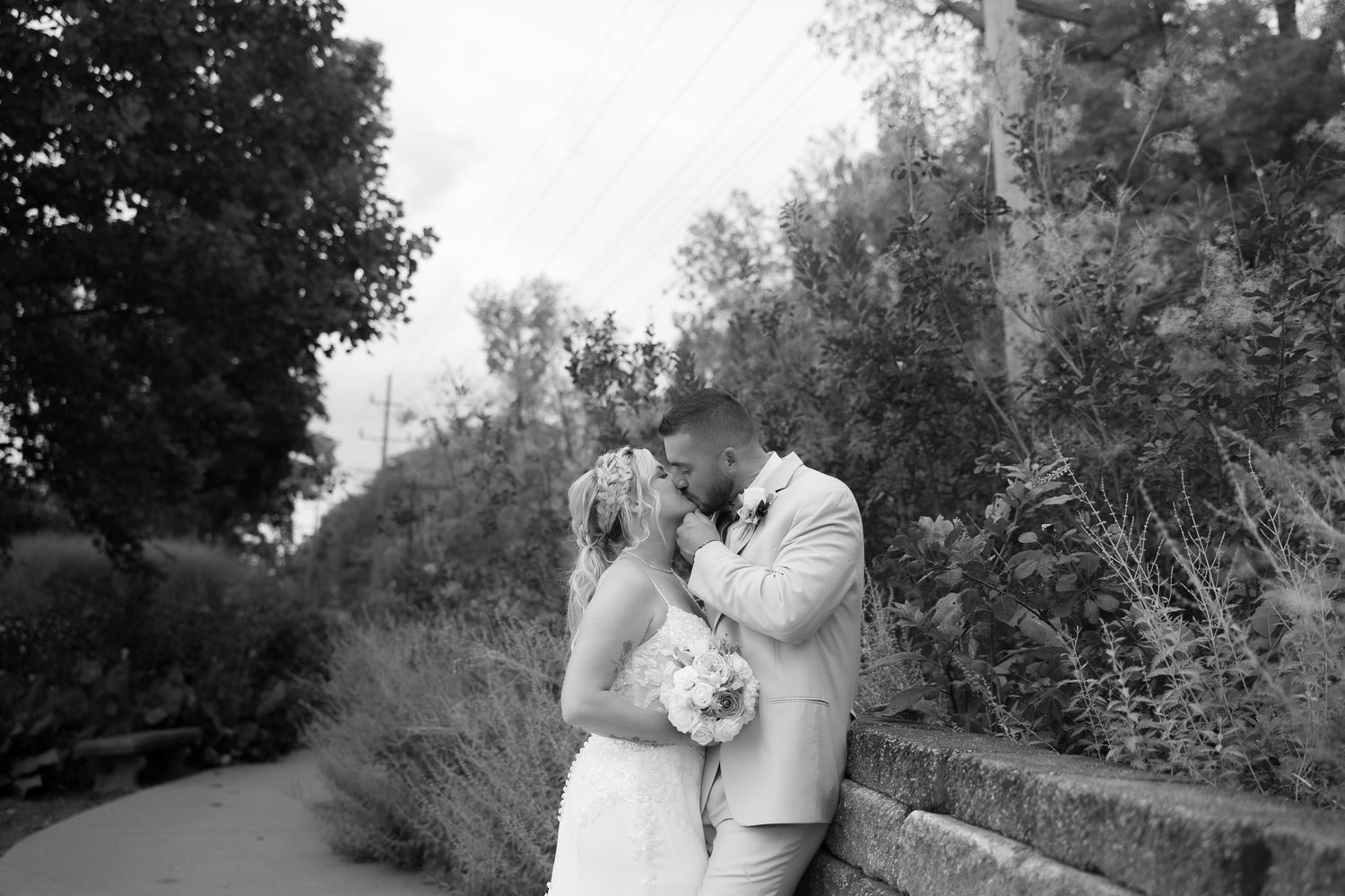 Black and white wedding photos captured in a garden setting with natural lighting.