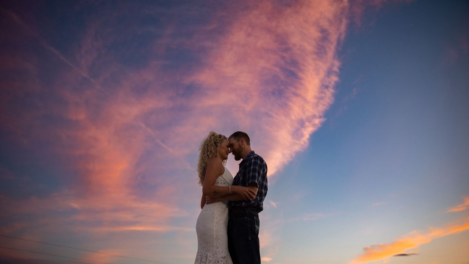Dramatic sunset sky with pink clouds creates romantic panoramic backdrop.