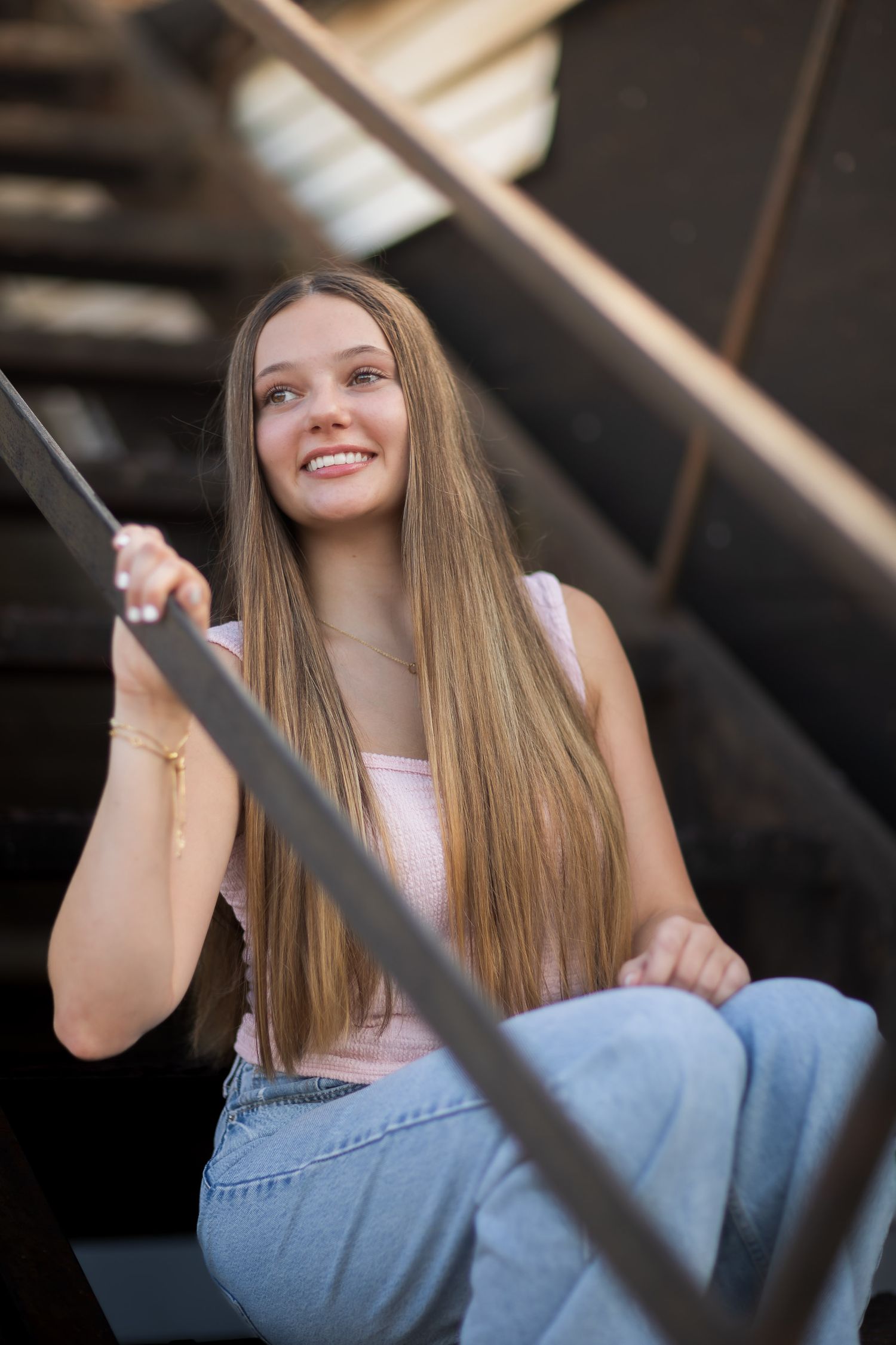Casual portrait session on wooden steps with natural lighting and diagonal lines.