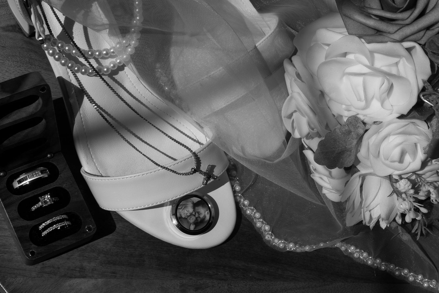 A collection of black and white wedding photography details showing rings, flowers, and decor elements.