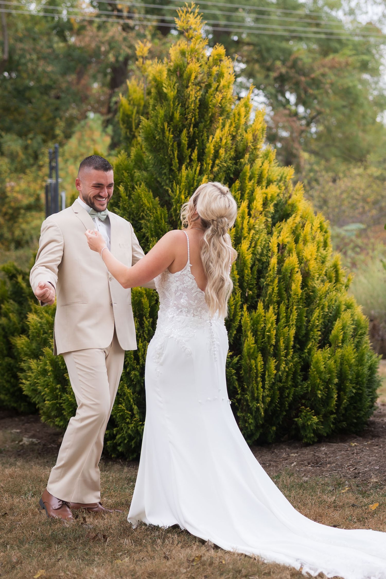 First look wedding photos captured in front of golden cypress trees during autumn.