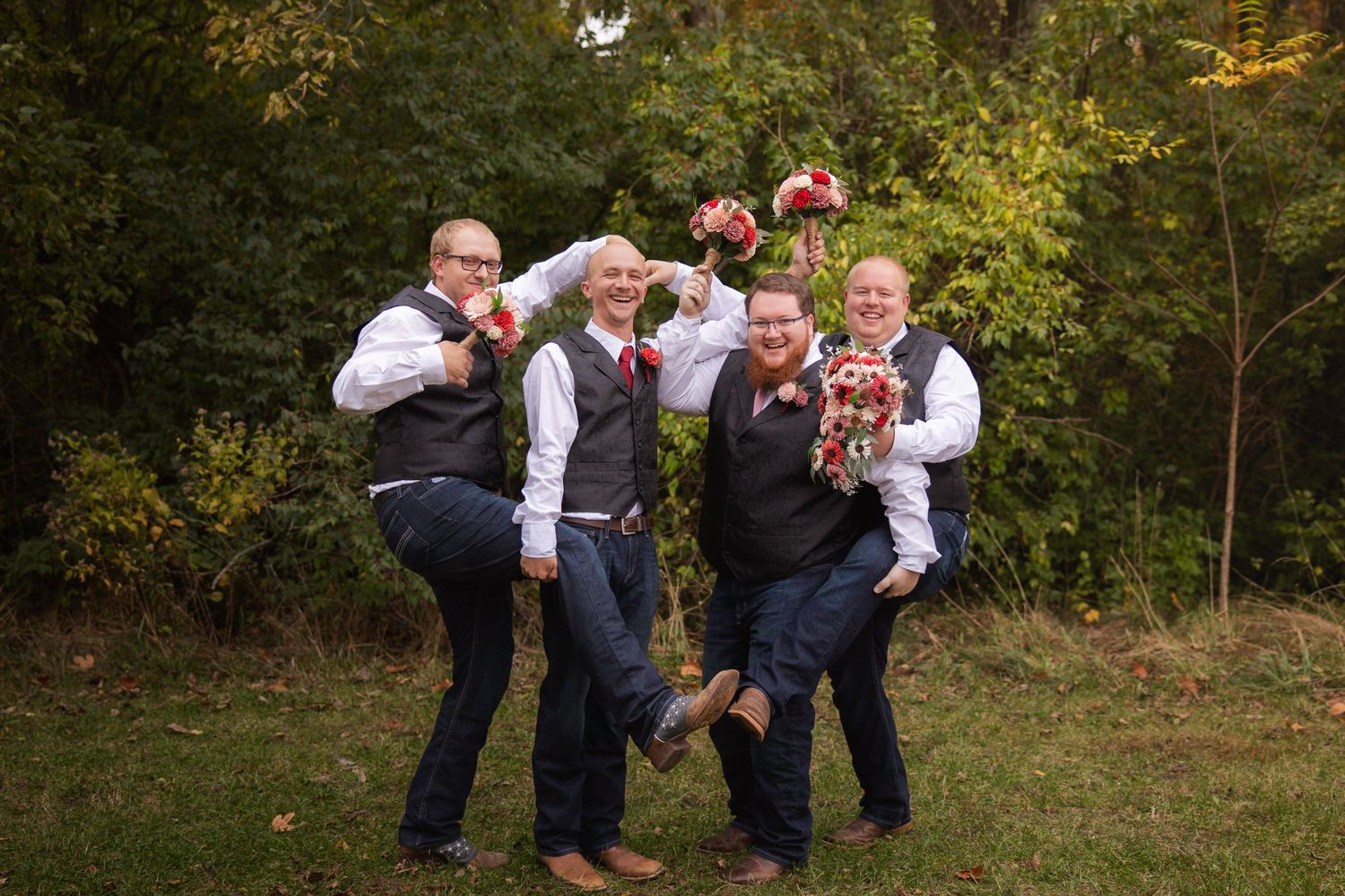 Wedding party shares laughter and joyful moments together in an outdoor autumn setting.