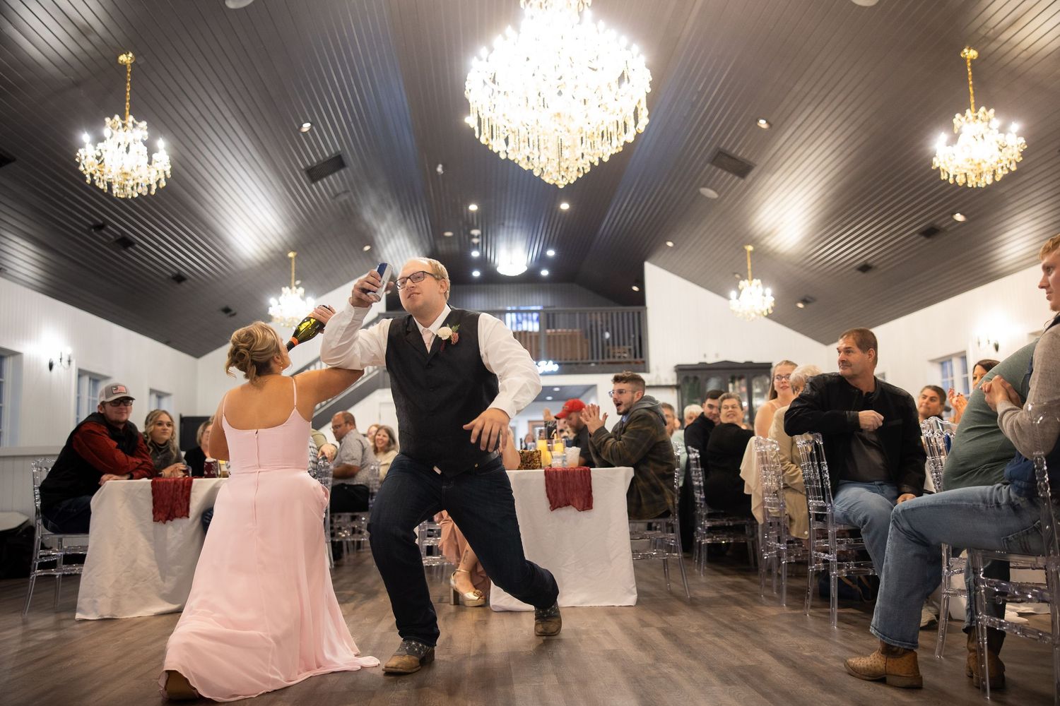 Wedding reception venue with elegant crystal chandeliers illuminating the dance floor.