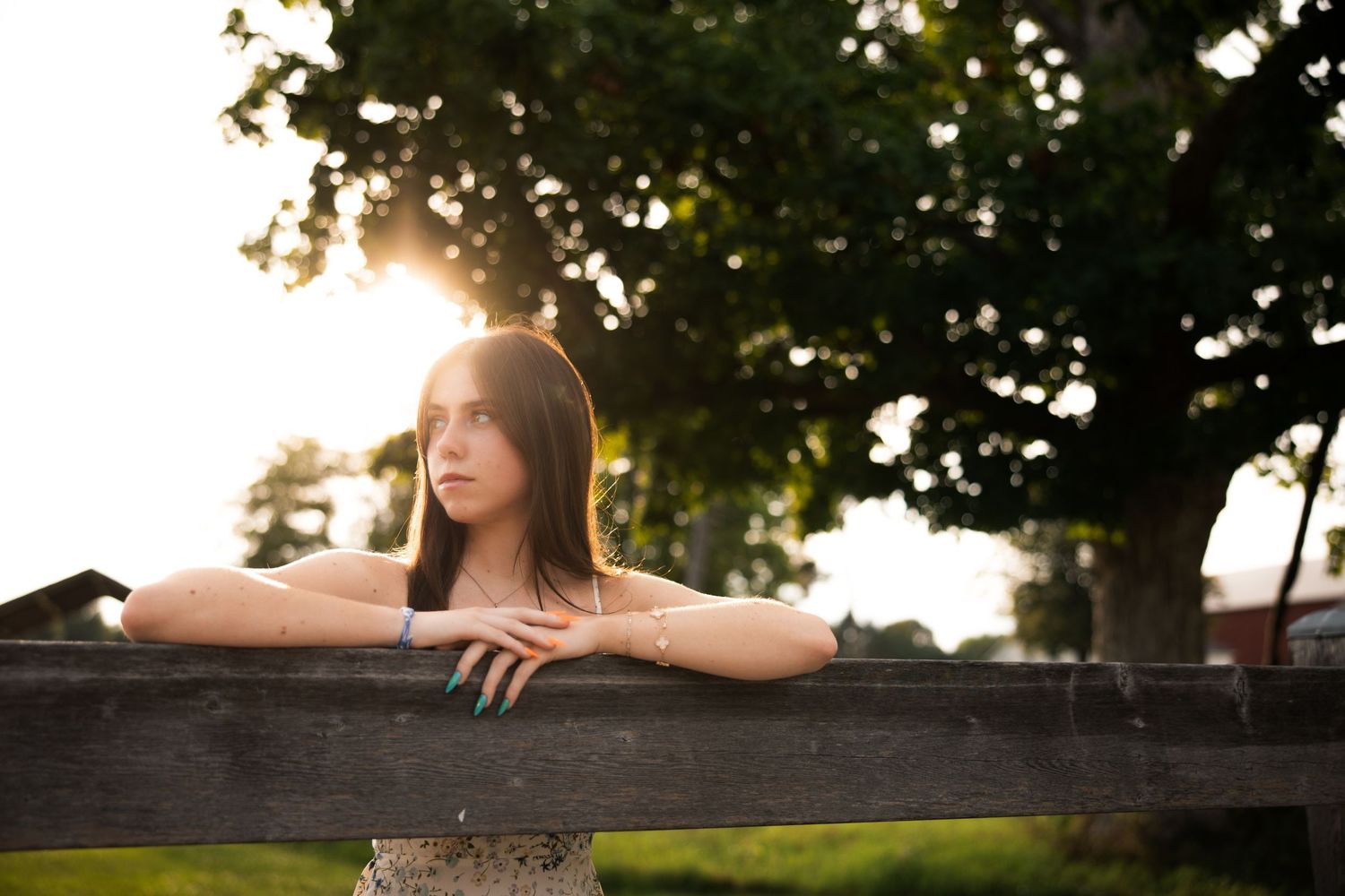 Sunset portrait series taken against a rustic wooden fence with golden hour lighting.