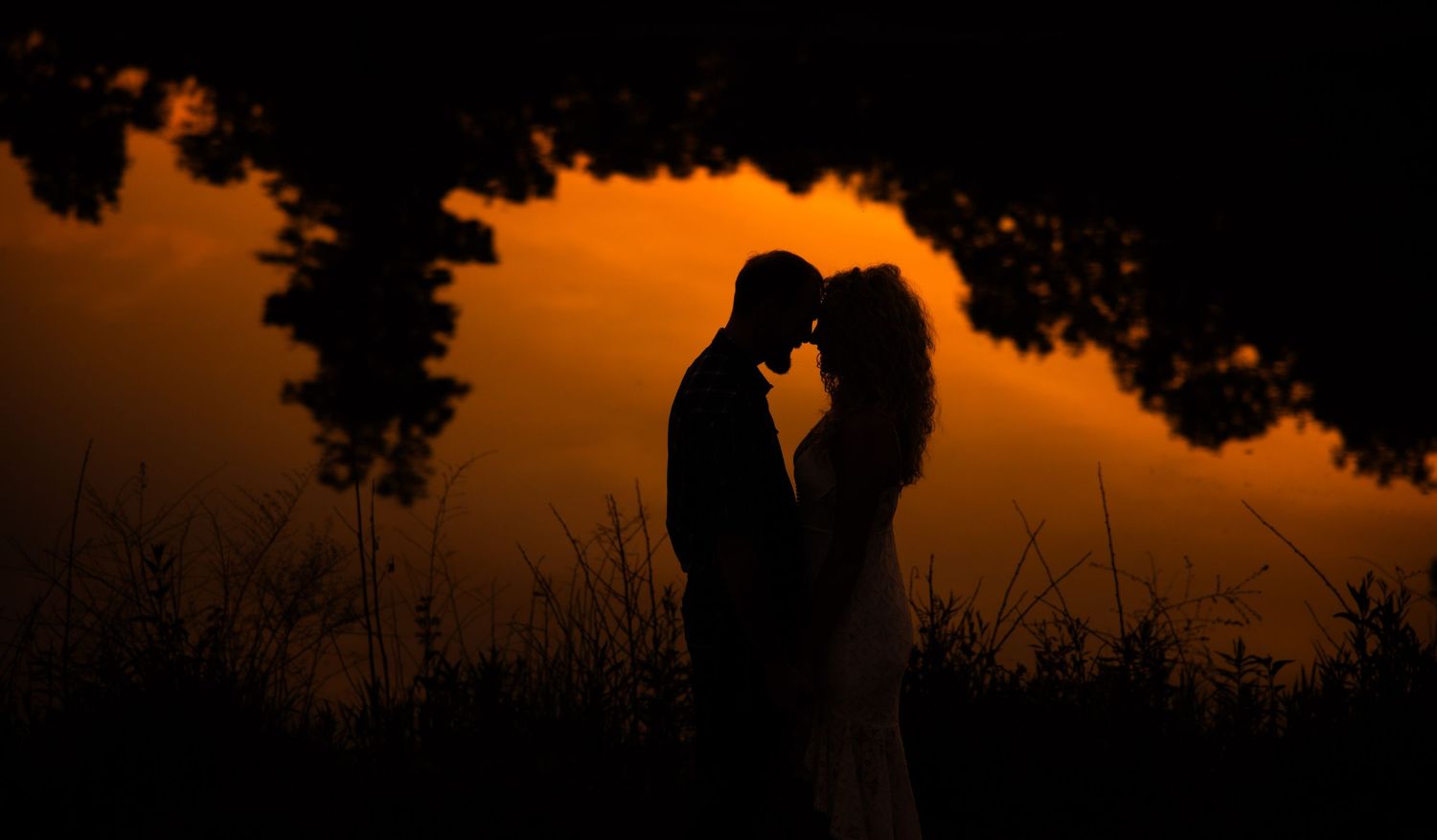 Silhouettes against an orange sunset creating a romantic atmosphere.