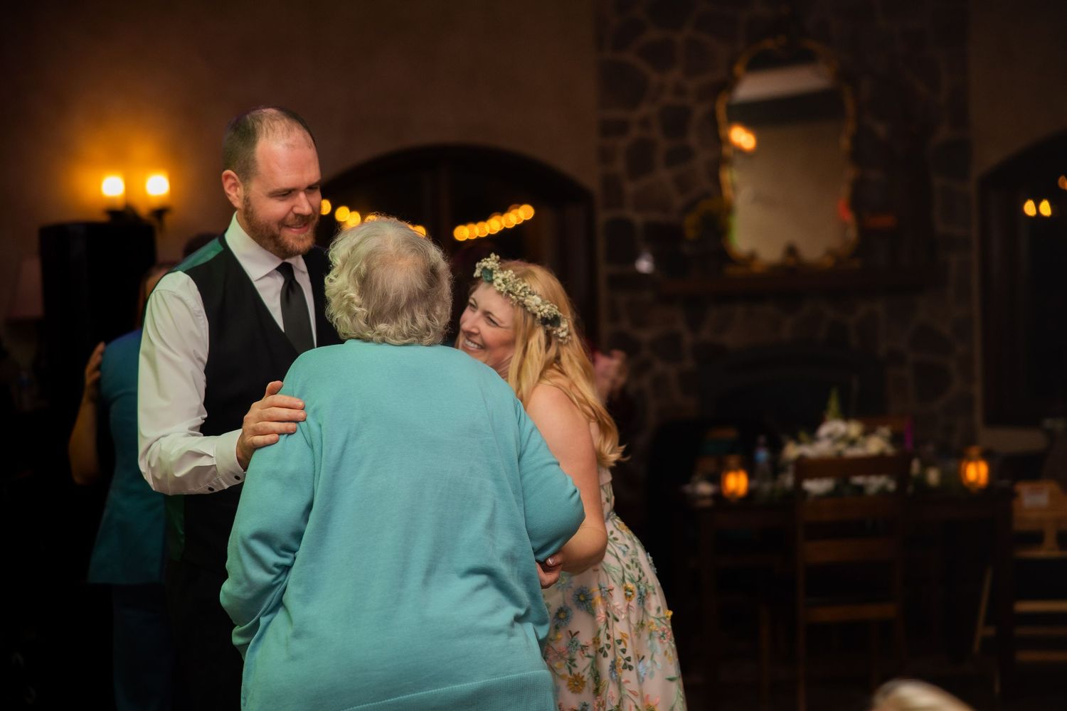 Wedding reception dance floor with guests enjoying themselves in warm lighting.