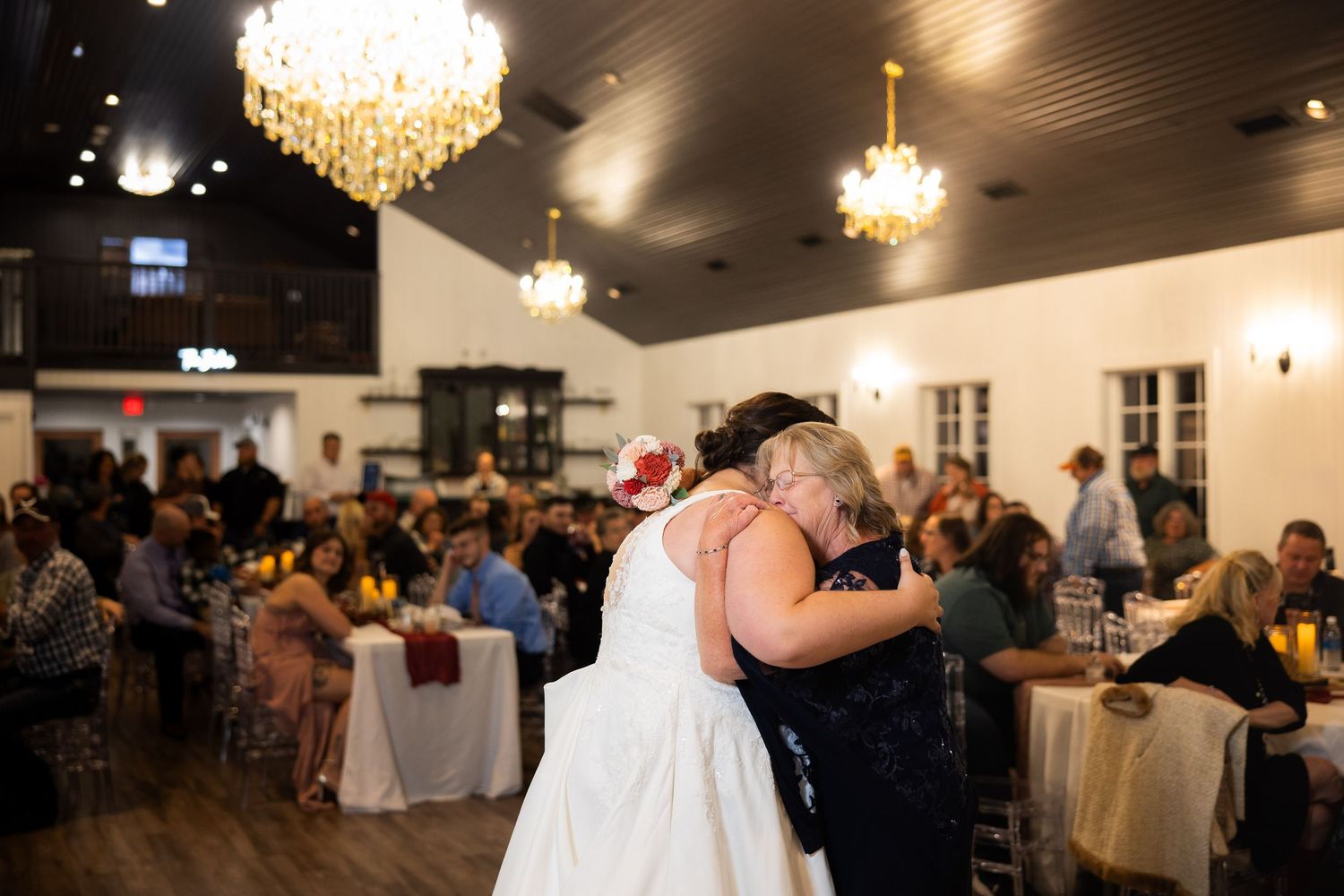 Elegant wedding reception with crystal chandeliers and dancing guests.