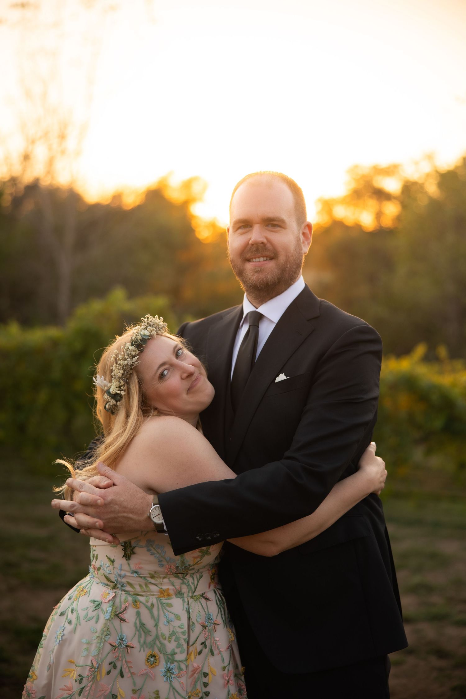 A romantic sunset dance dip captured during a wedding celebration outdoors.