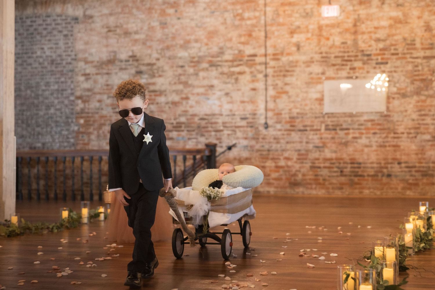 Wedding venue features exposed brick walls illuminated by warm candlelight and string lights.