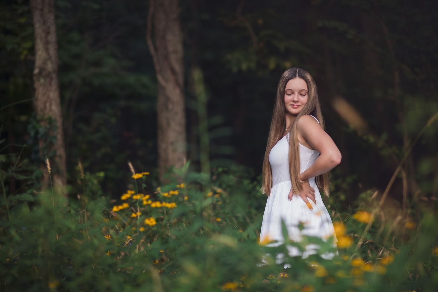 Outdoor summer portrait with yellow wildflowers and natural lighting.