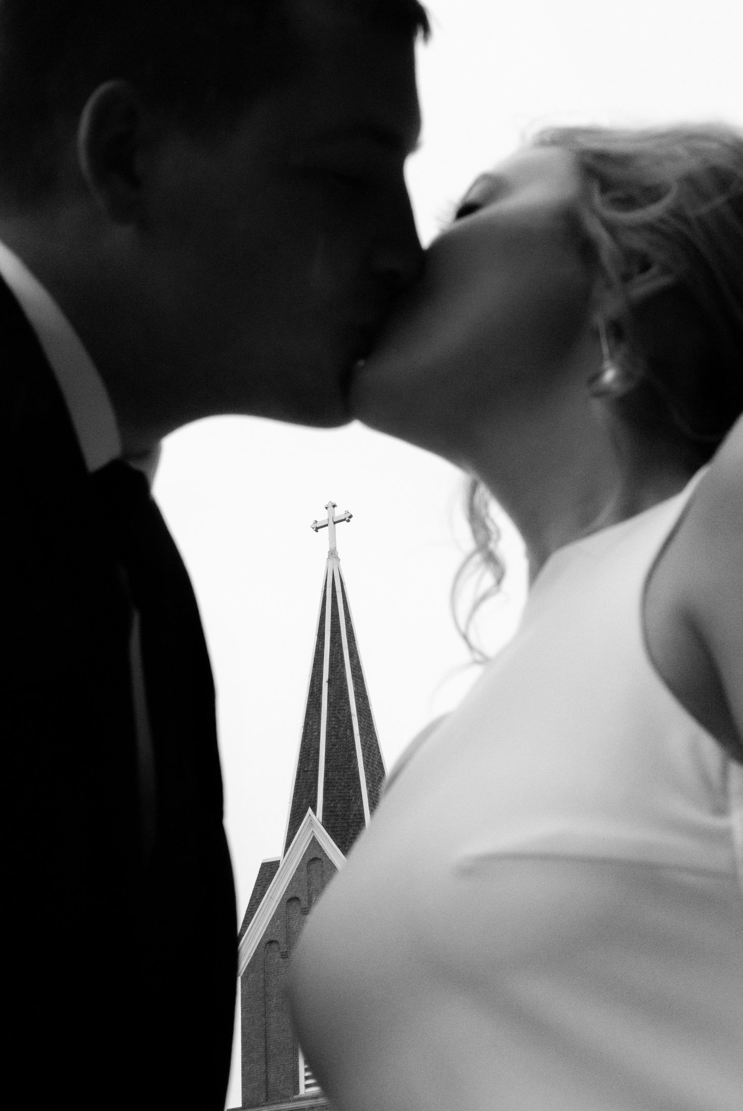 Church steeples and crosses silhouetted against a bright background during a wedding ceremony.