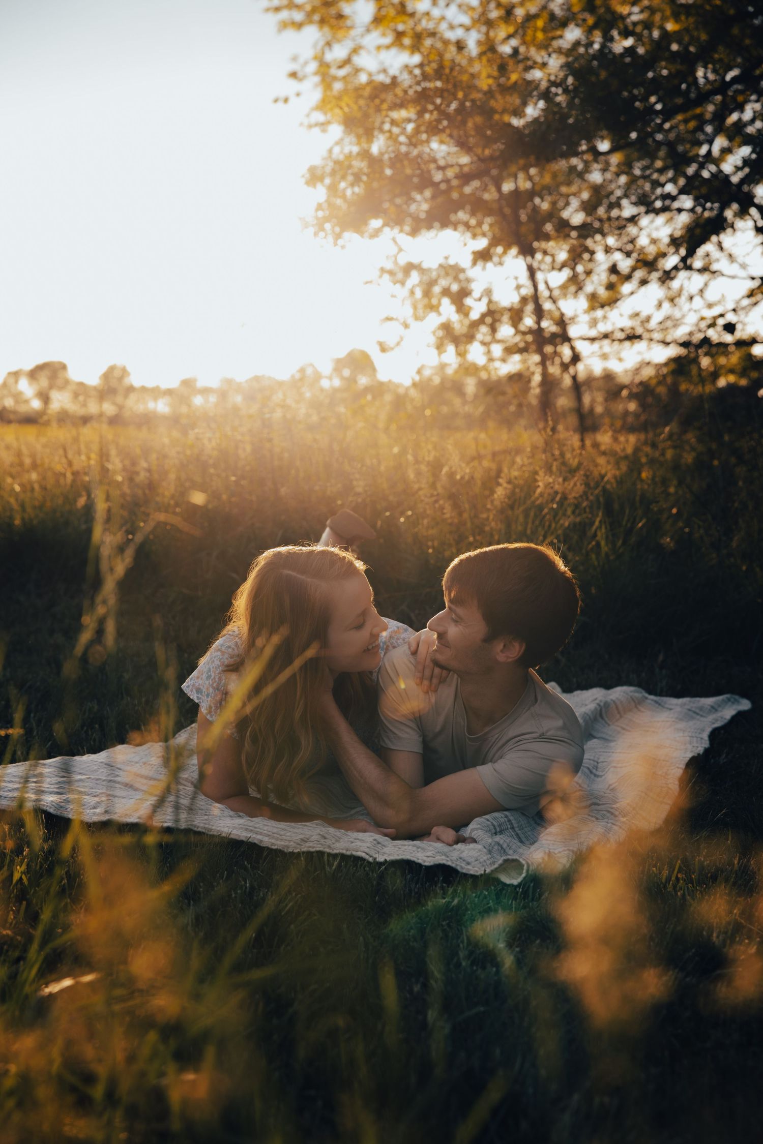 Golden sunset light filters through trees in romantic outdoor setting.