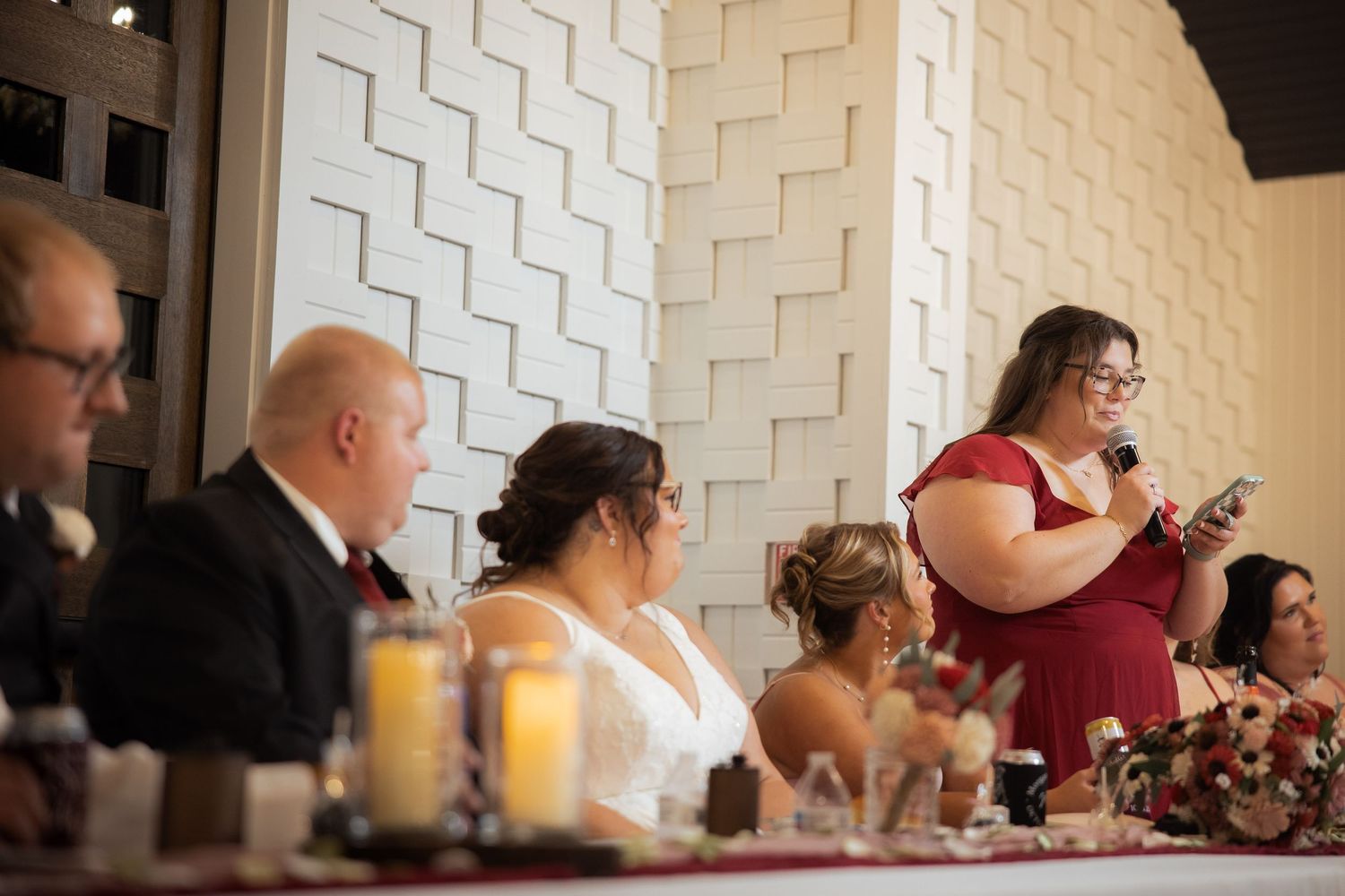 Textured white geometric wall pattern provides modern backdrop for wedding reception seating.