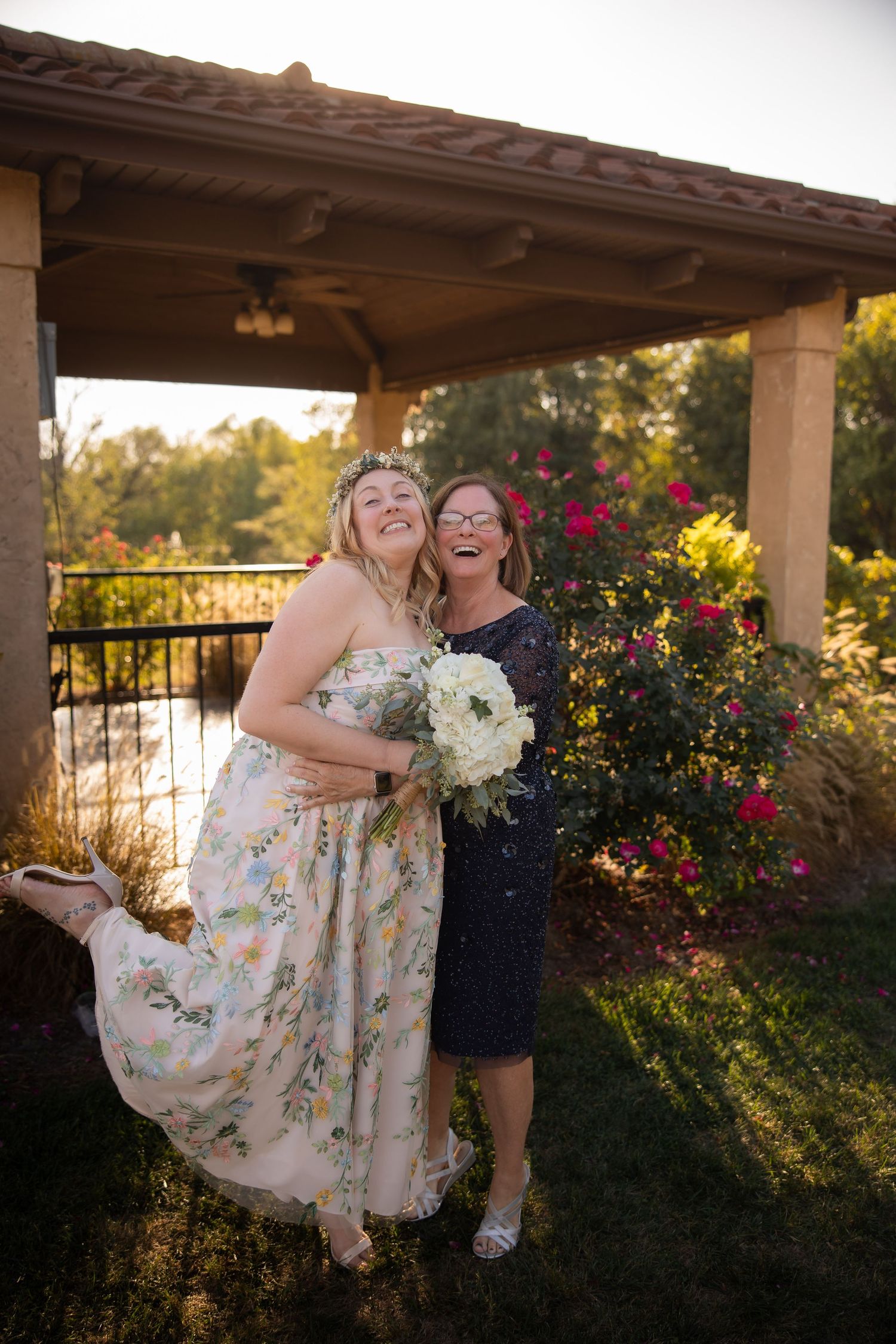 A floral dress twirls during a romantic dance moment under a covered patio with garden backdrop.