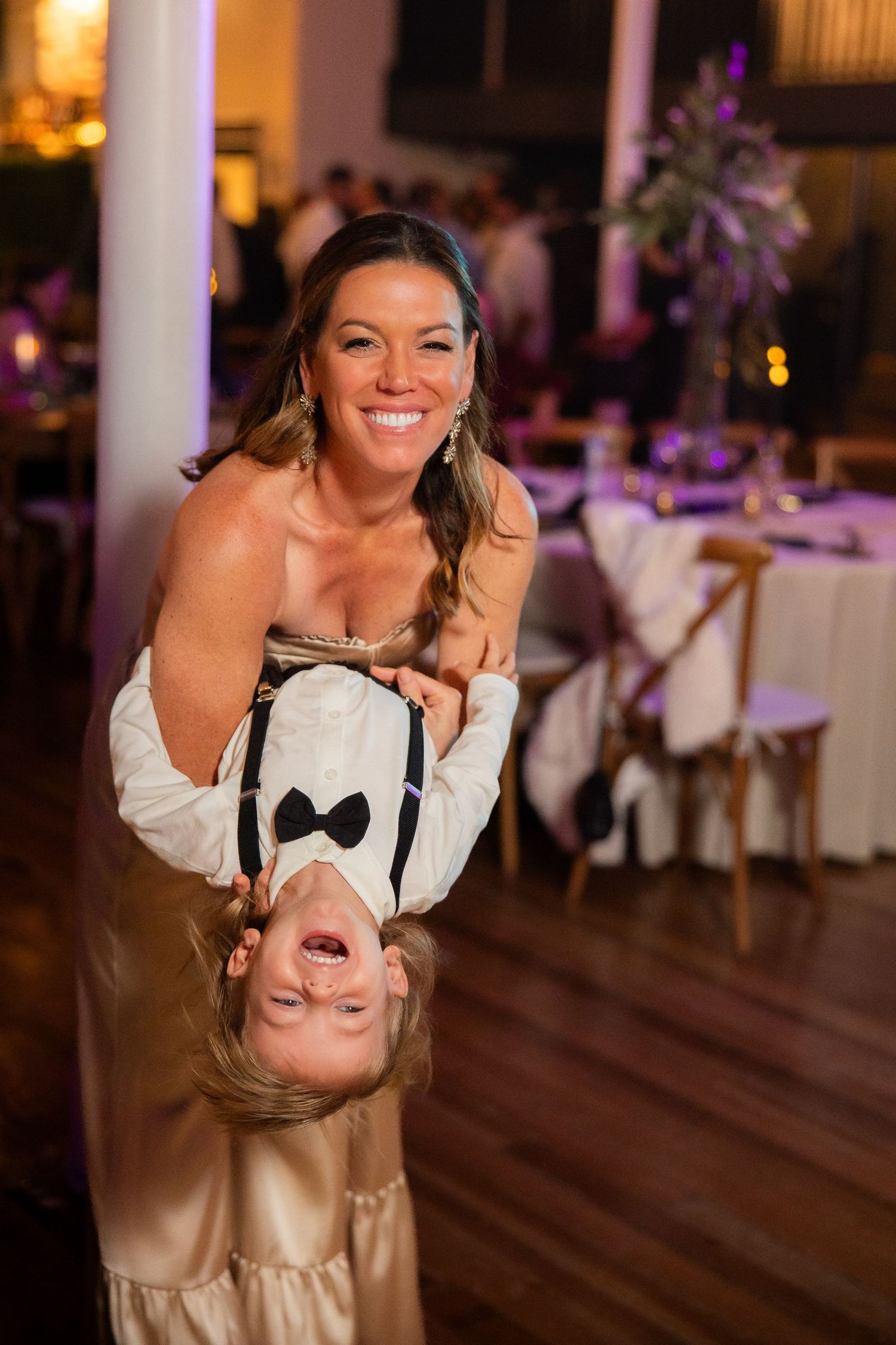 A guest at a wedding reception having fun and dancing in formal attire.