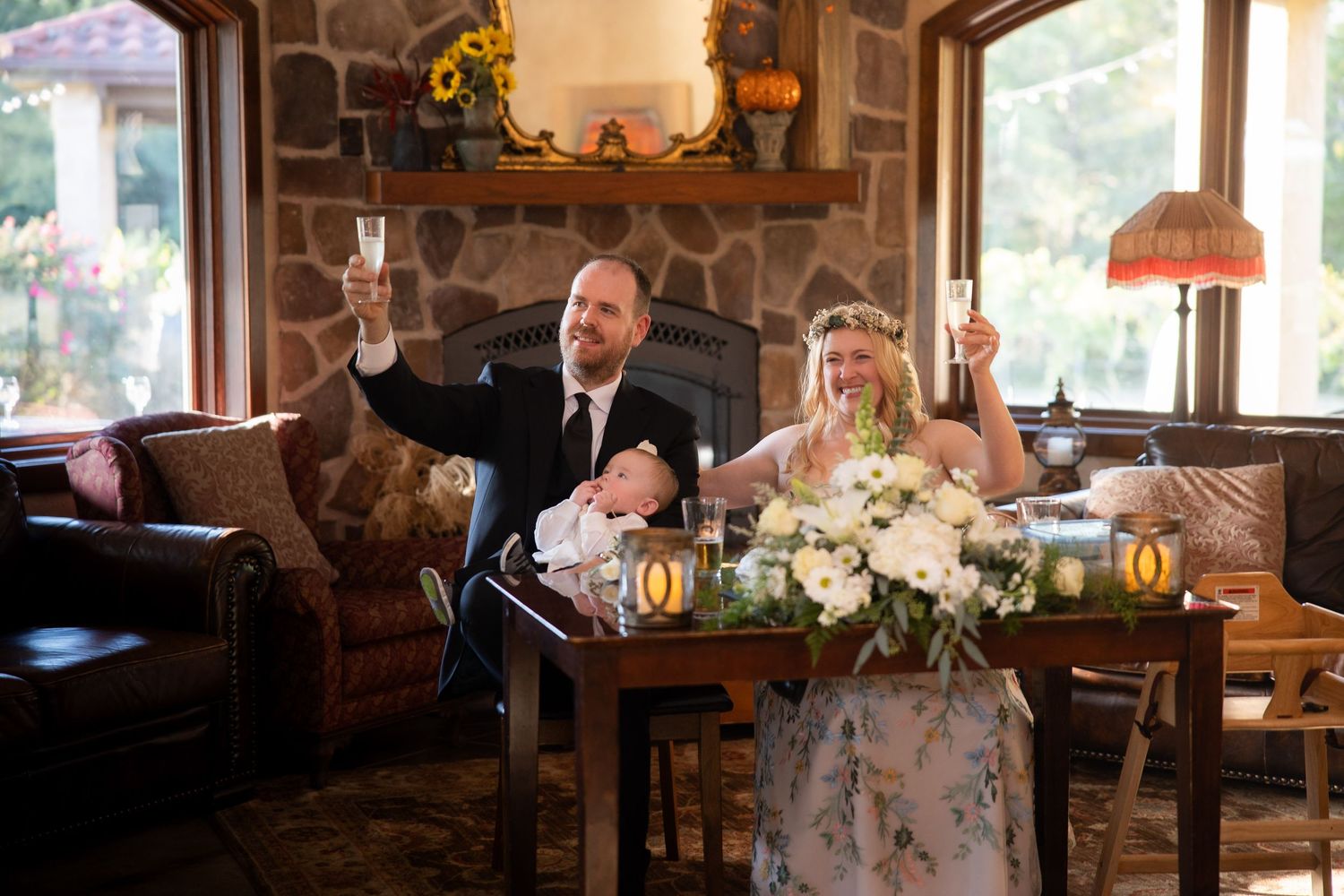 A rustic indoor reception venue decorated with sunflowers and string lights.