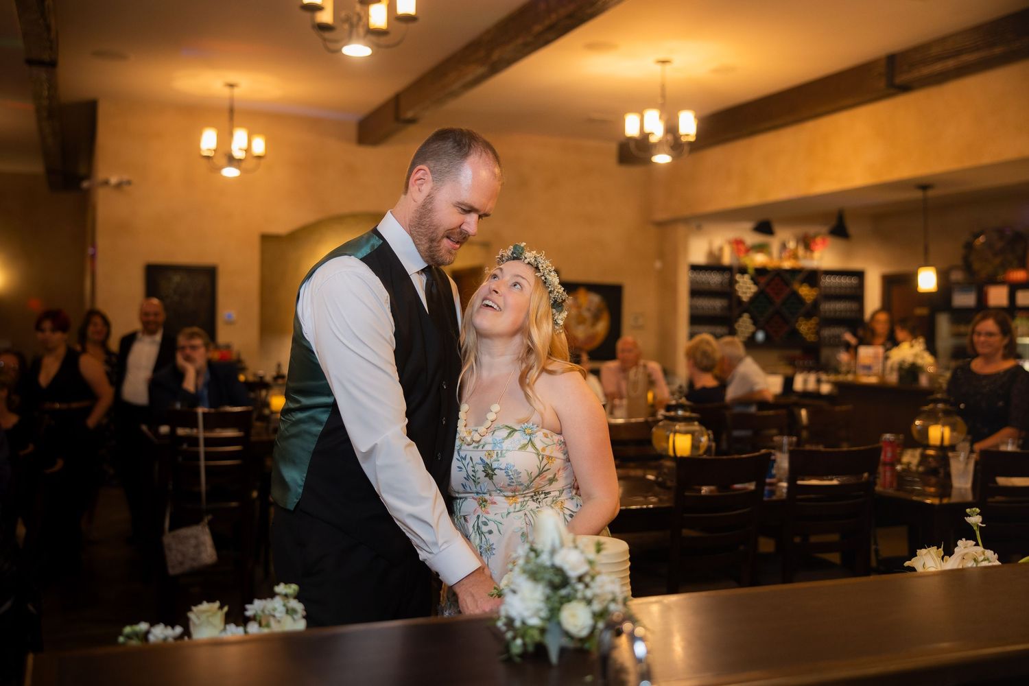 Wedding reception in a rustic venue with exposed wooden beams and warm lighting.