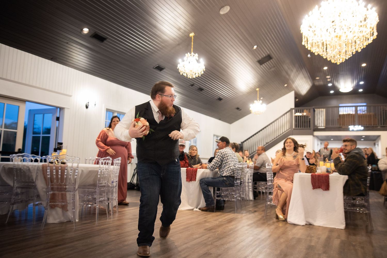 Wedding reception venue with elegant chandeliers and dark ceiling showing multiple angles of the dance floor.