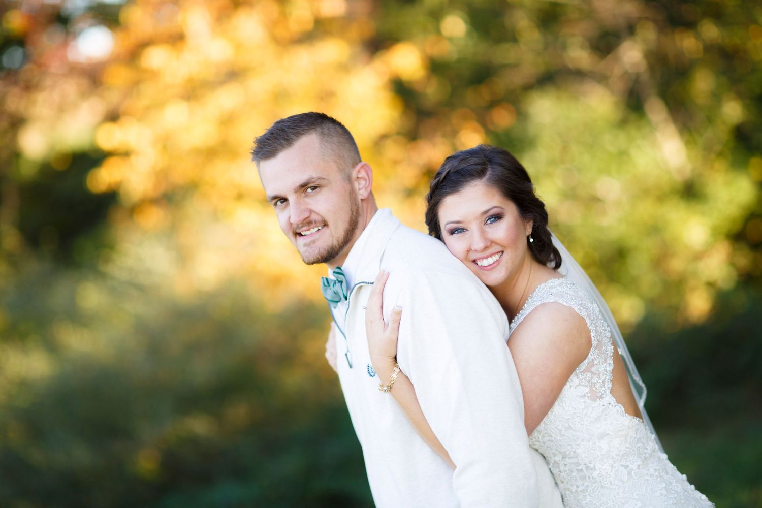 Romantic autumn wedding portraits in a garden with golden sunlight.