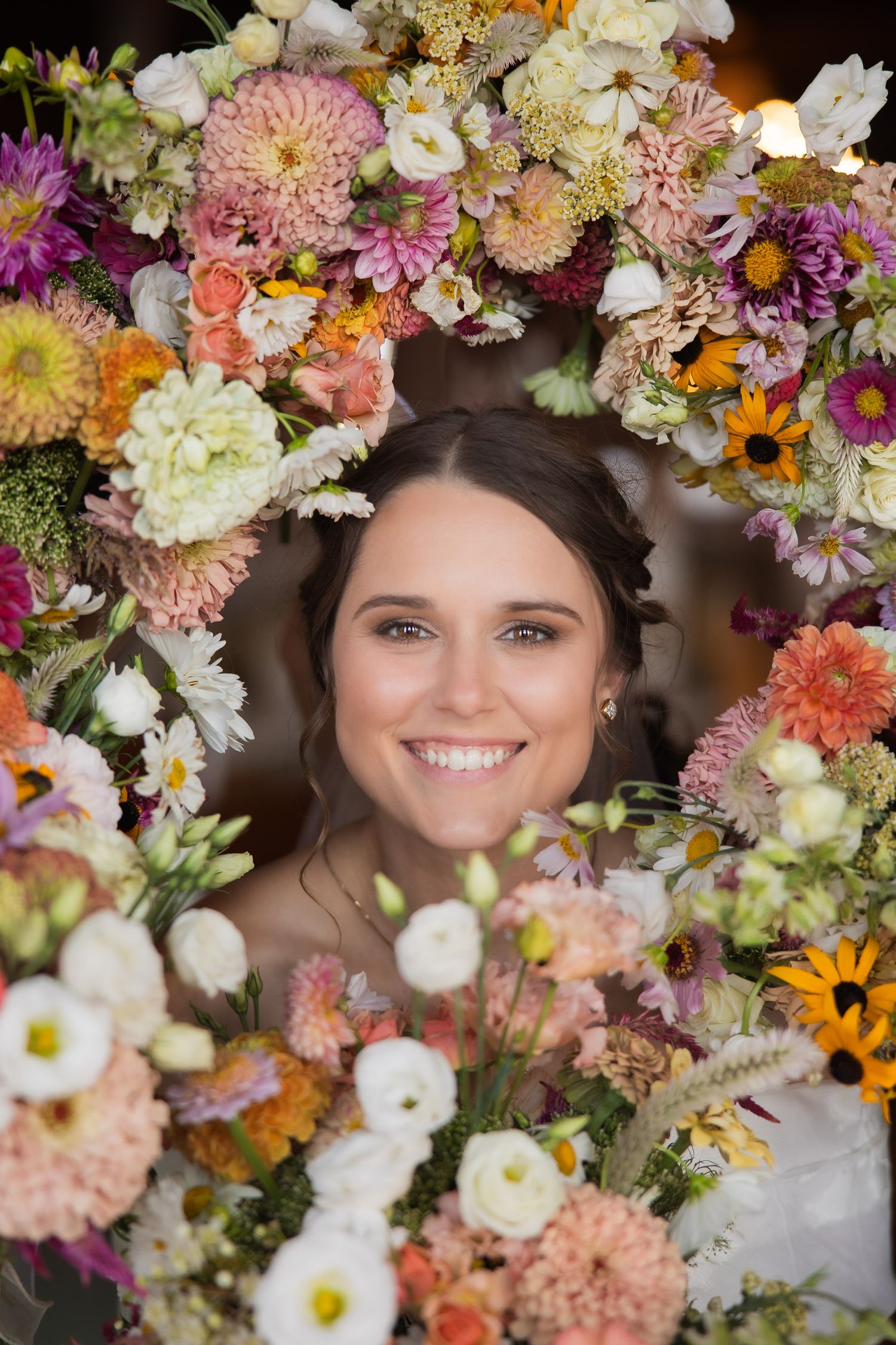 Colorful floral arrangement with white, pink, and orange blooms framing a natural scene.