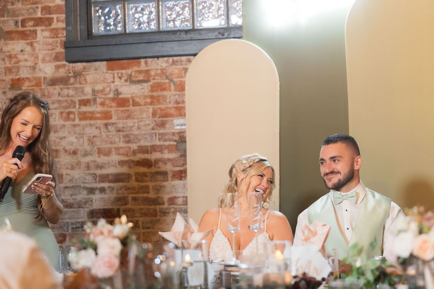 Wedding reception venue with exposed brick walls and elegant table settings.