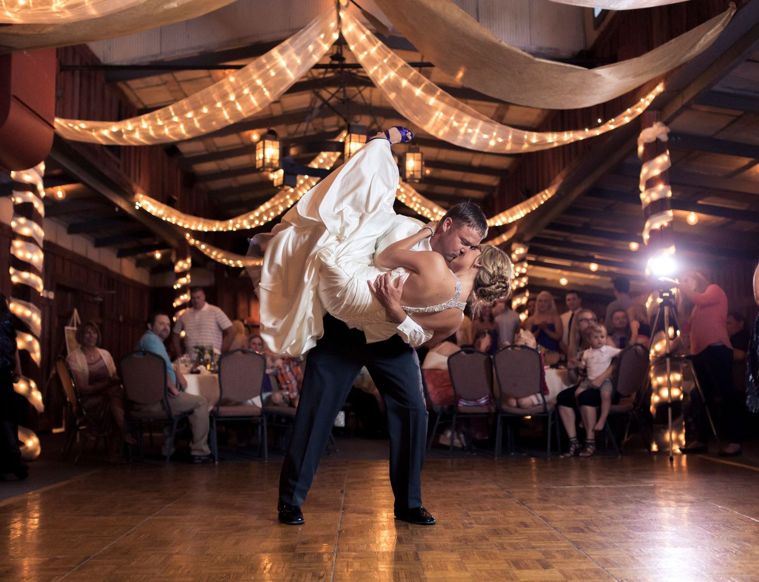 Wedding reception dance floor with twinkle lights and fabric draping overhead.