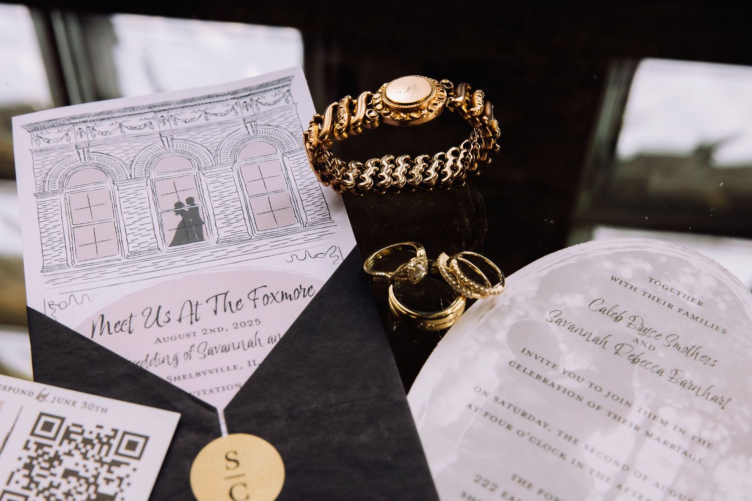 Wedding details including jewelry, rings, and handwritten notes arranged artistically on a dark surface.