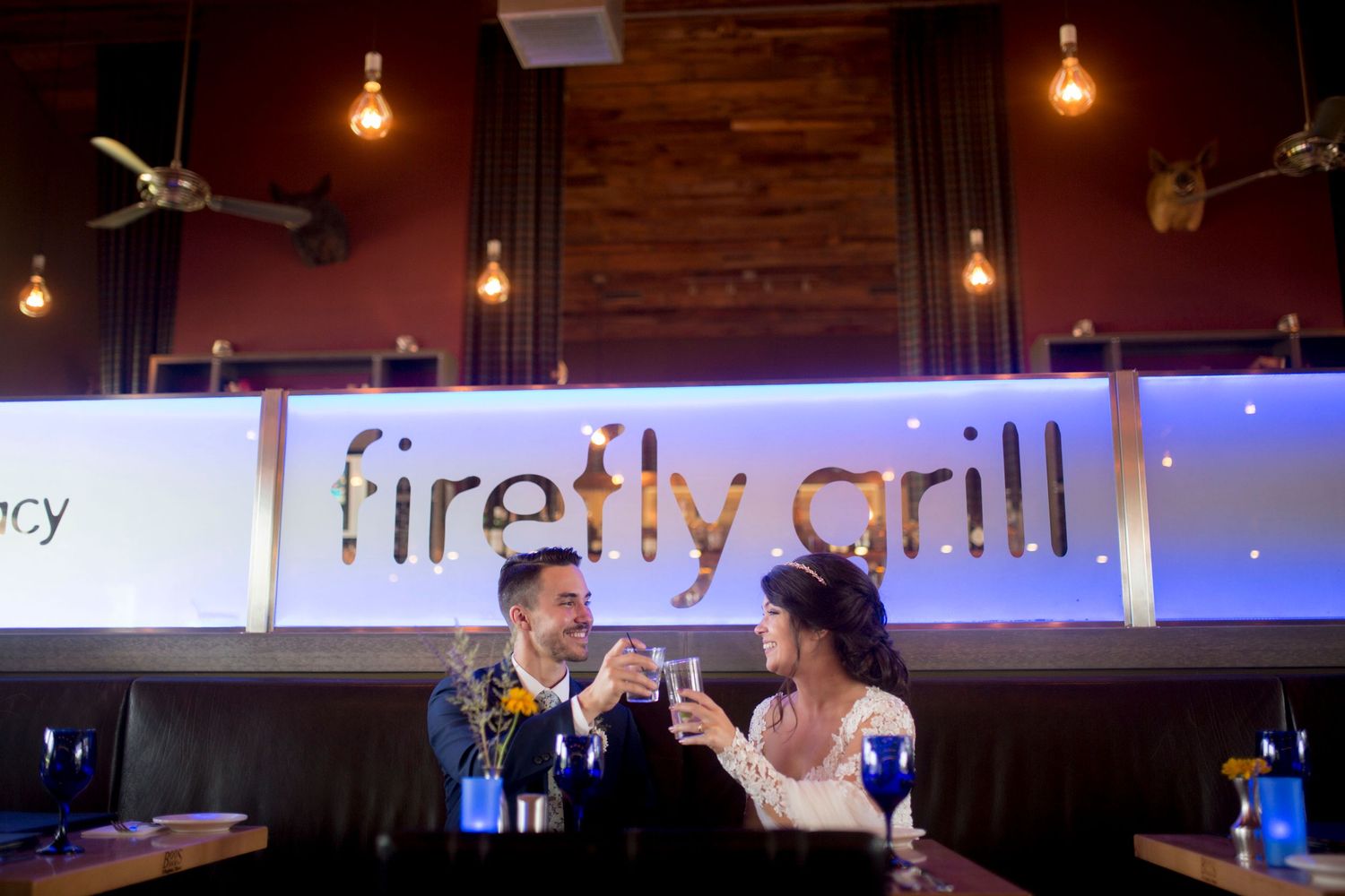 Wedding reception venue decorated with warm hanging lights and rustic industrial elements.