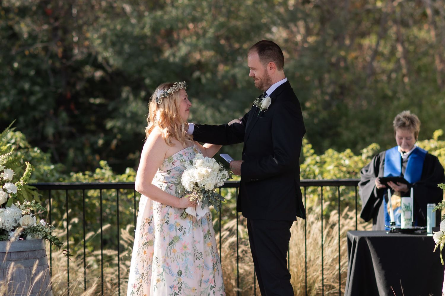 A romantic outdoor wedding moment captured on a stone patio with decorative railings.